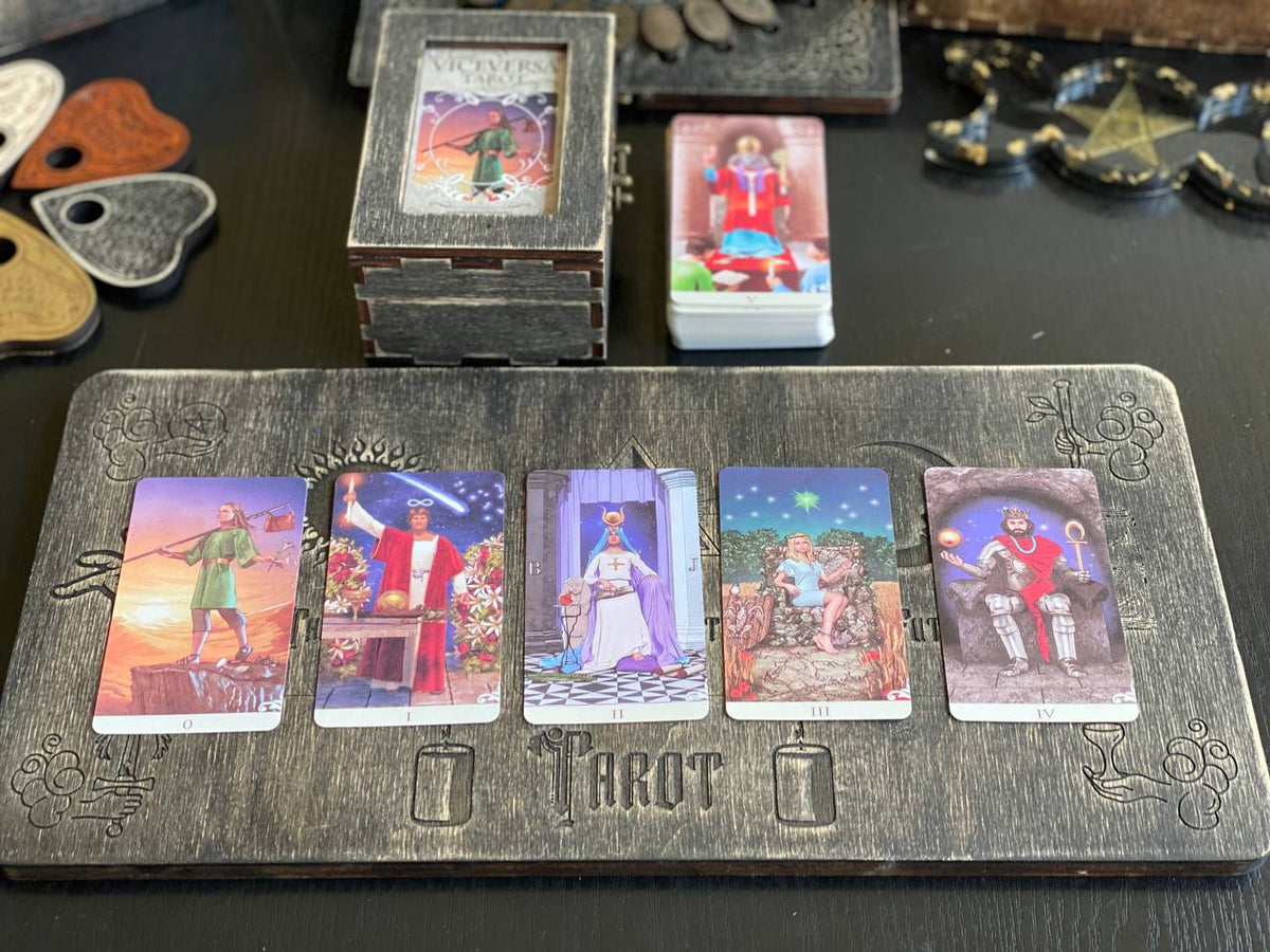 a collection of tarot cards arranged on a wooden board, with the word "TAROT" written on the board.