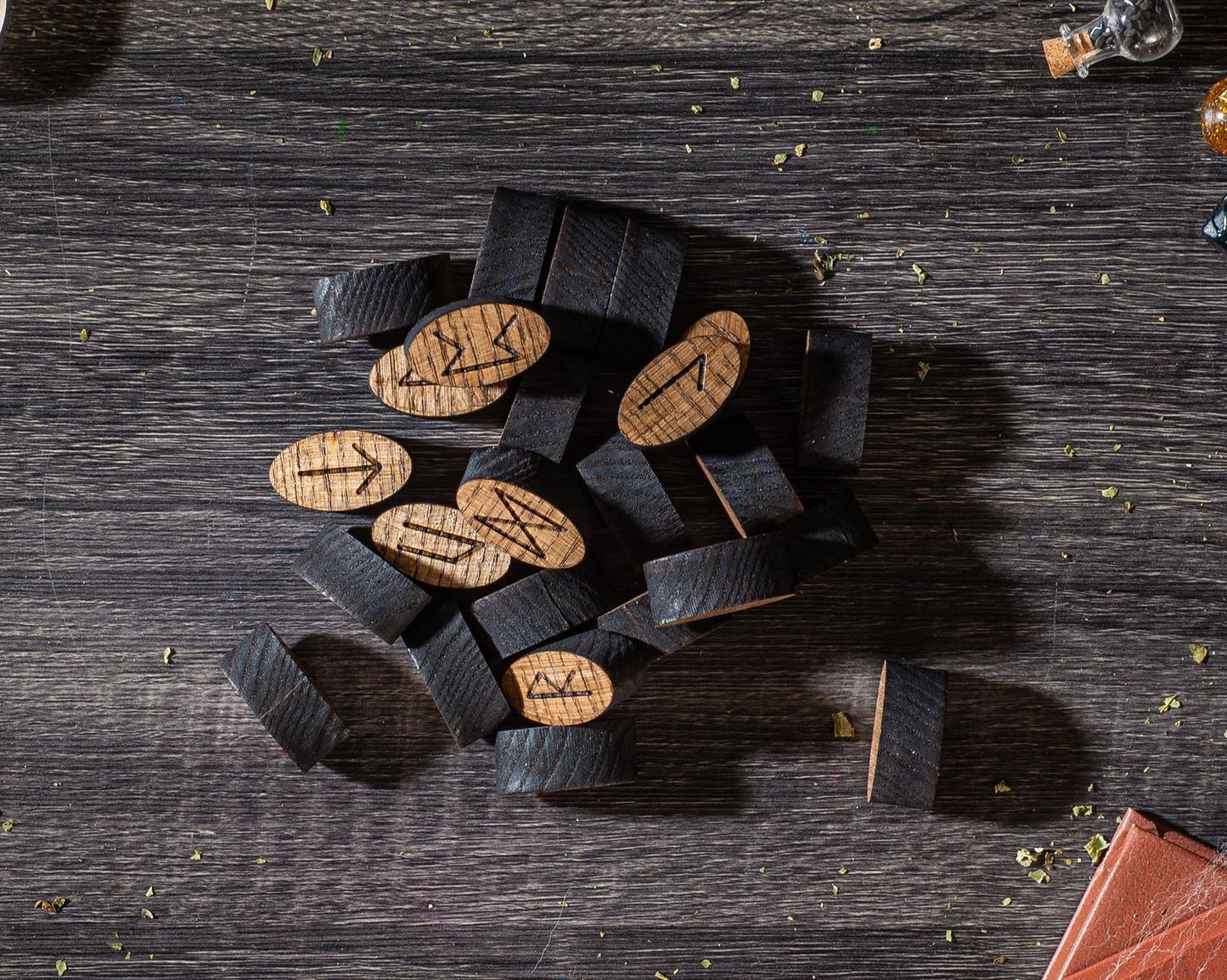 a collection of wooden objects, including several oval-shaped pieces with carved designs, scattered on a wooden surface.