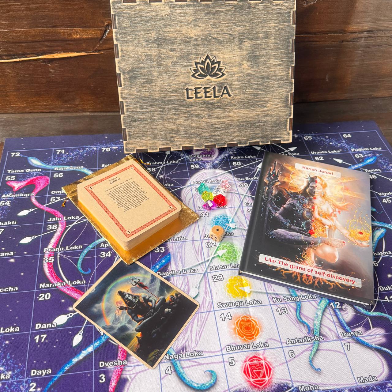 a collection of items related to a board game, including a wooden box, a book, a game board, and various game pieces and cards.