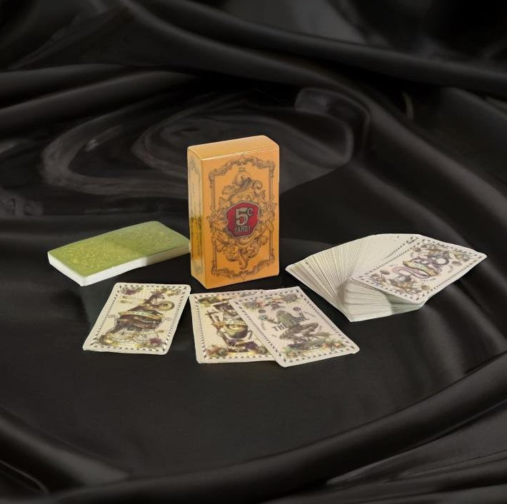 a deck of playing cards, a box of playing cards, and a green and white playing card on a black background.