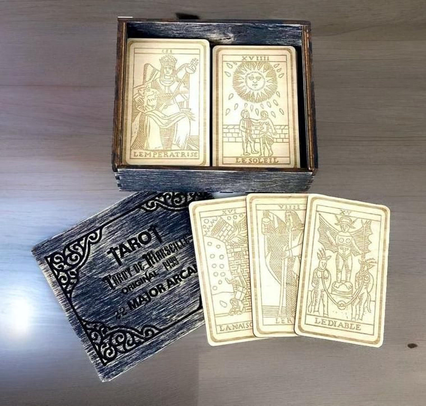 a tarot deck with a wooden box containing the deck and a set of cards.