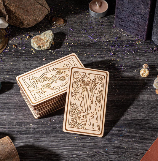 a collection of wooden tarot cards, including a full deck and a smaller, folded deck, arranged on a wooden surface.