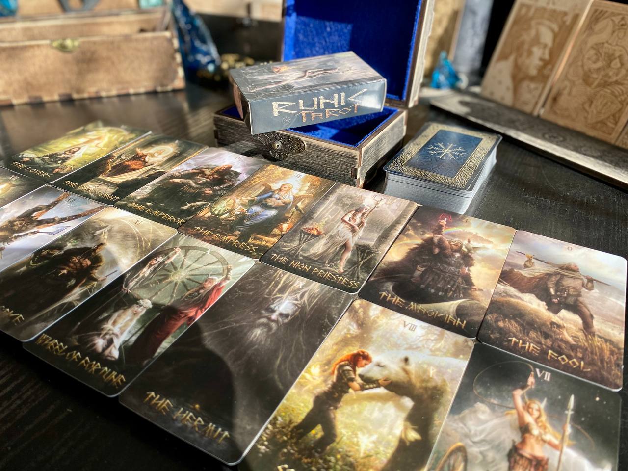 a collection of tarot cards and a tarot card box, arranged on a table.