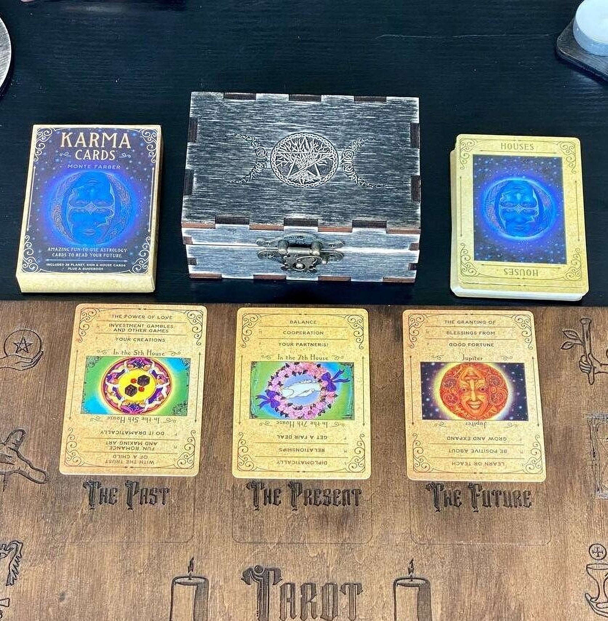 a collection of tarot cards and a wooden box on a table.