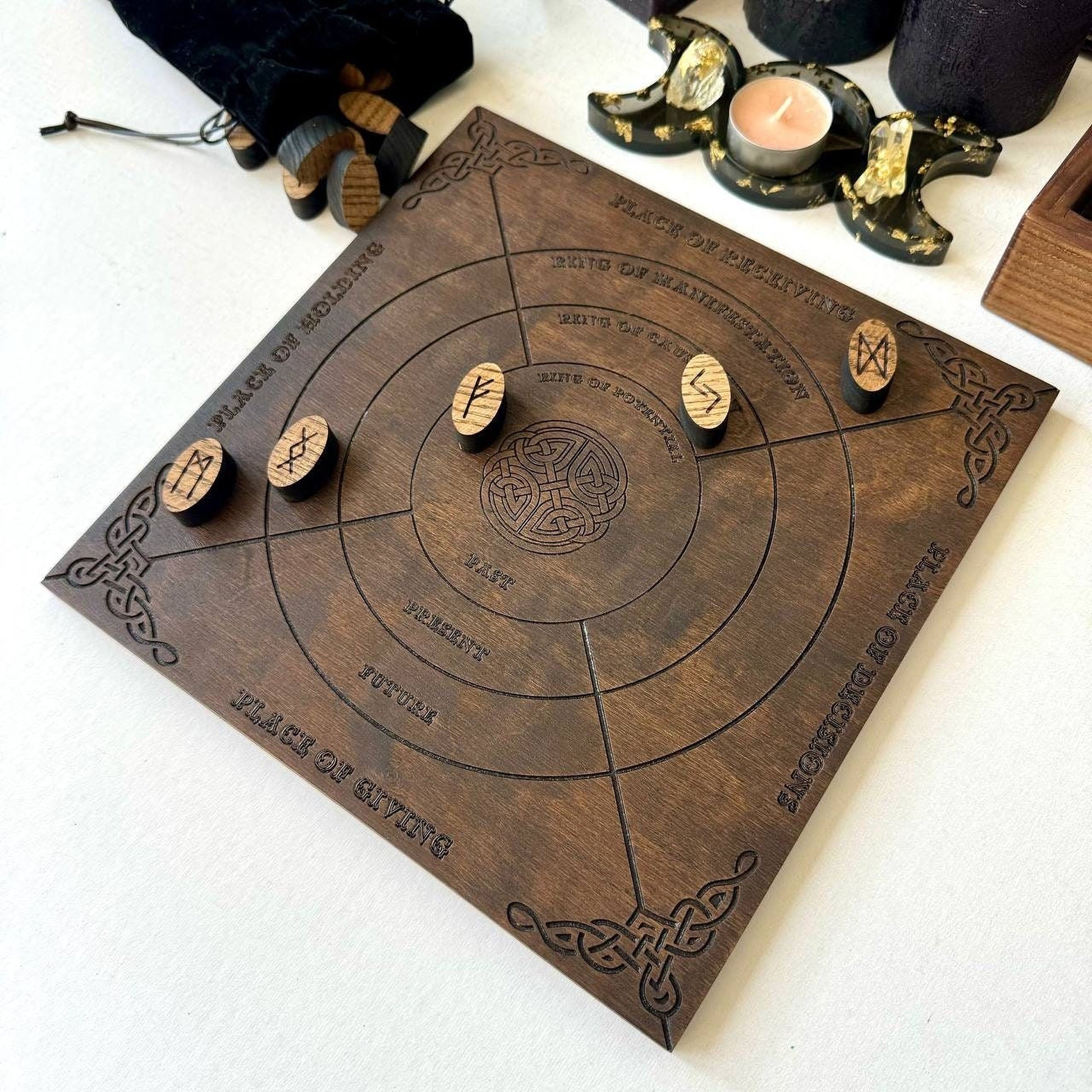 a wooden board with various symbols and text, including a crescent moon, a candle, and a wooden staff.