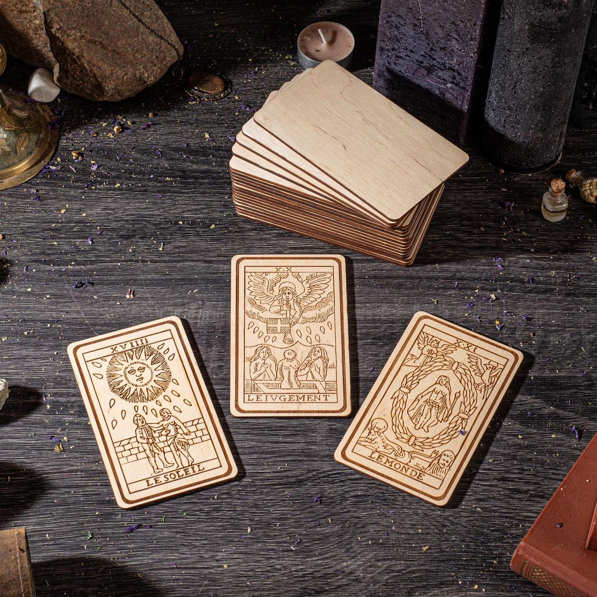 three wooden tarot cards with intricate designs, placed on a wooden surface.