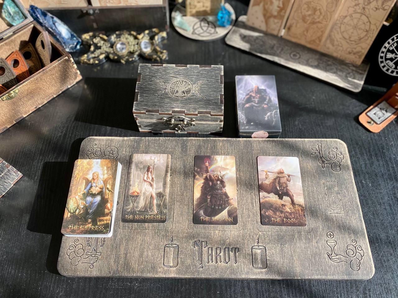 a tarot card reader's table with various tarot cards and a wooden tray.