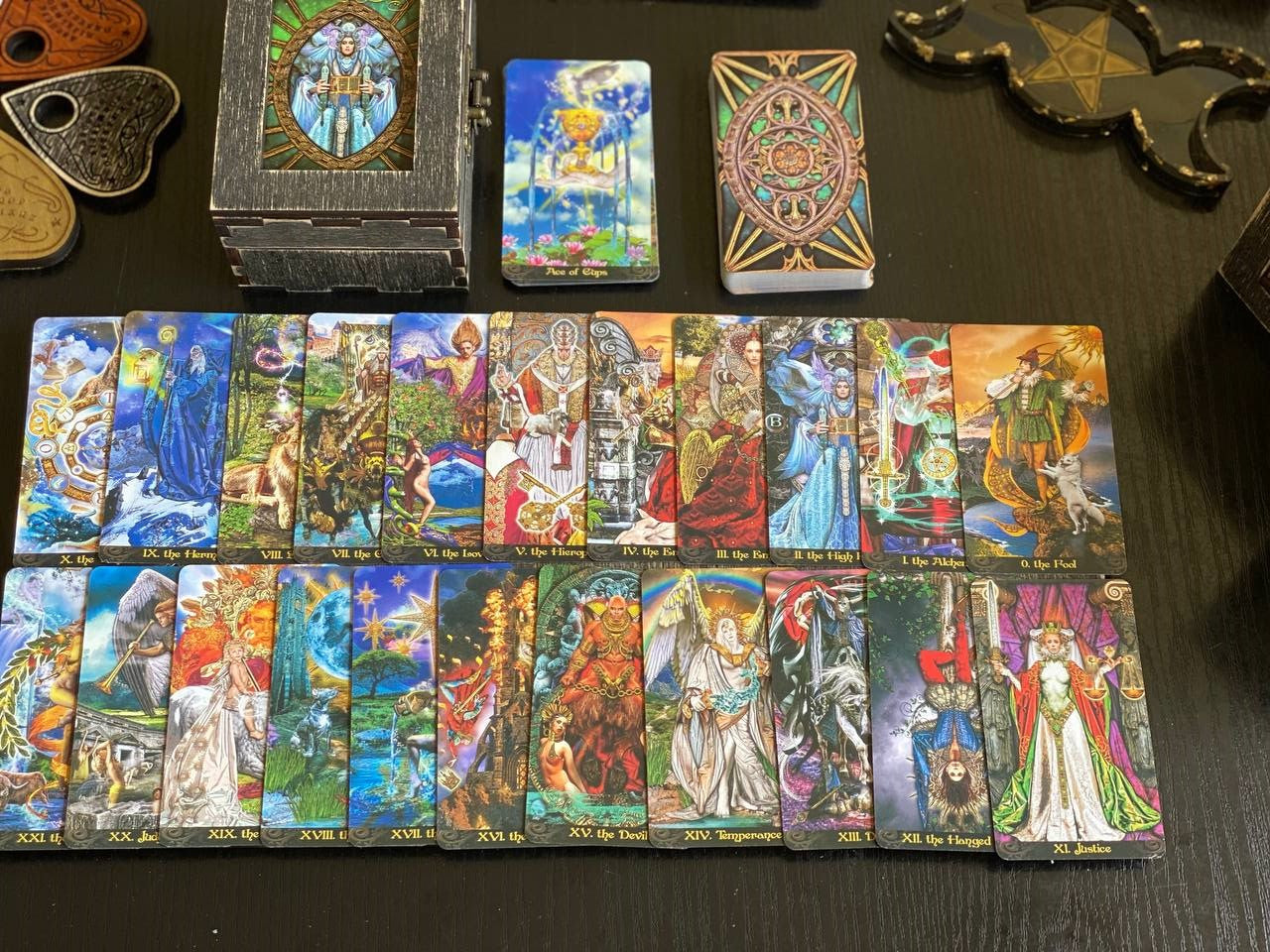 a collection of tarot cards and fortune teller tools arranged on a dark surface.