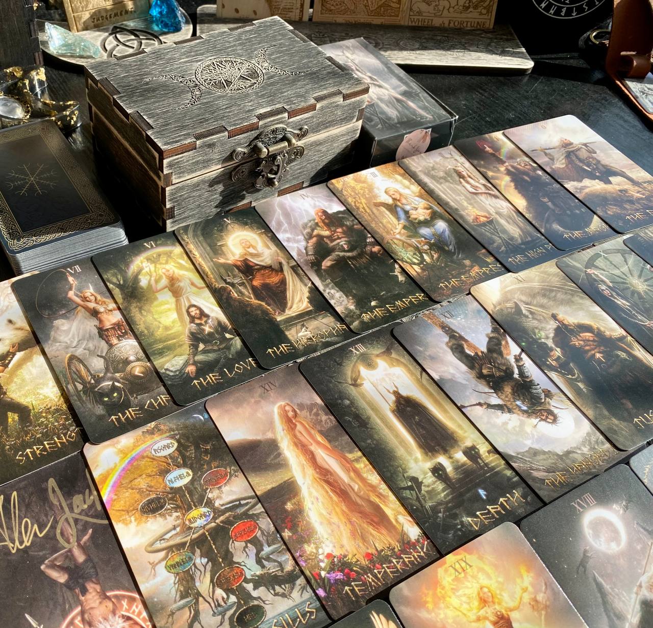 a collection of tarot cards spread out on a table, each card featuring a different scene or character.