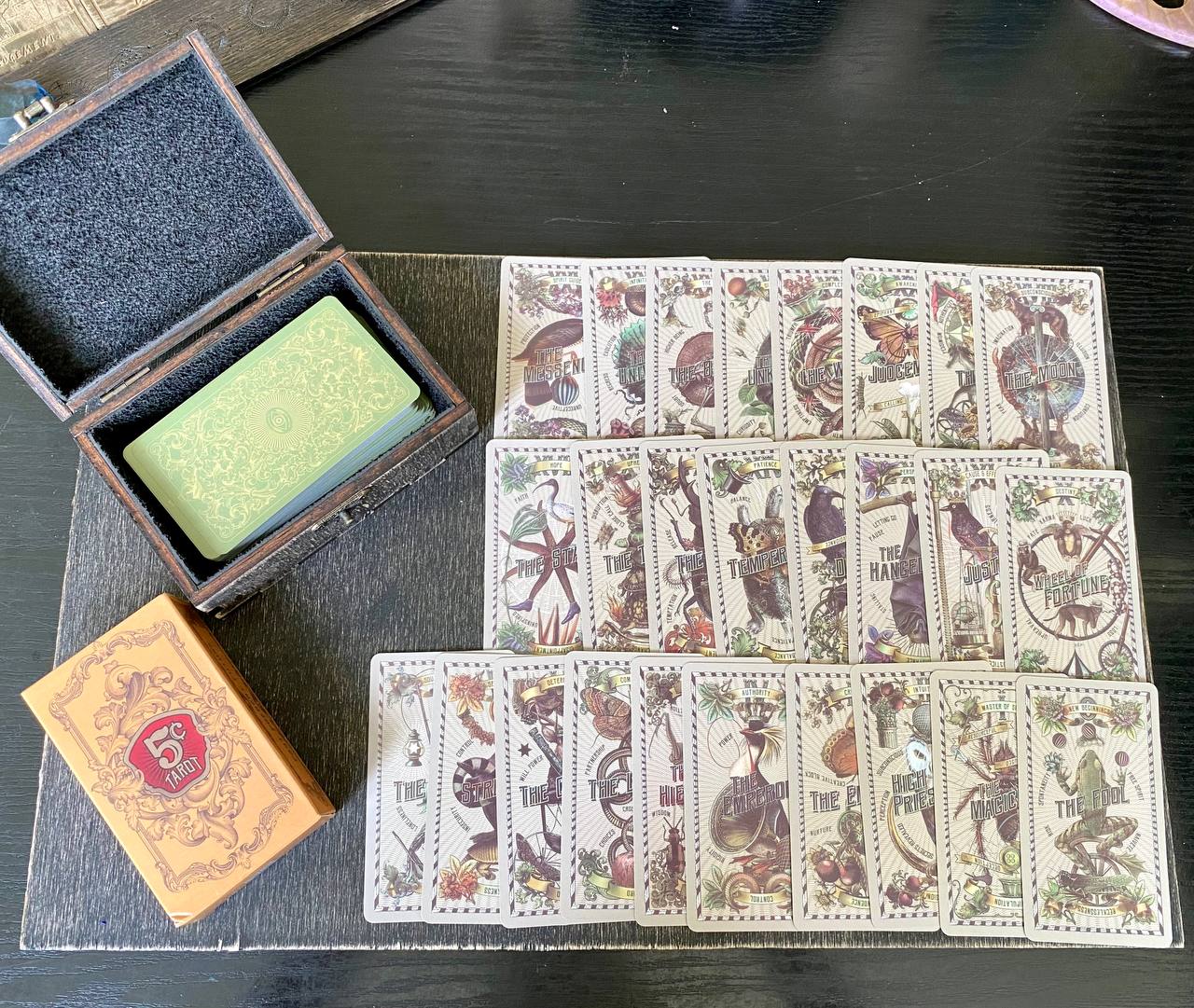 a collection of playing cards and a wooden box on a wooden surface.