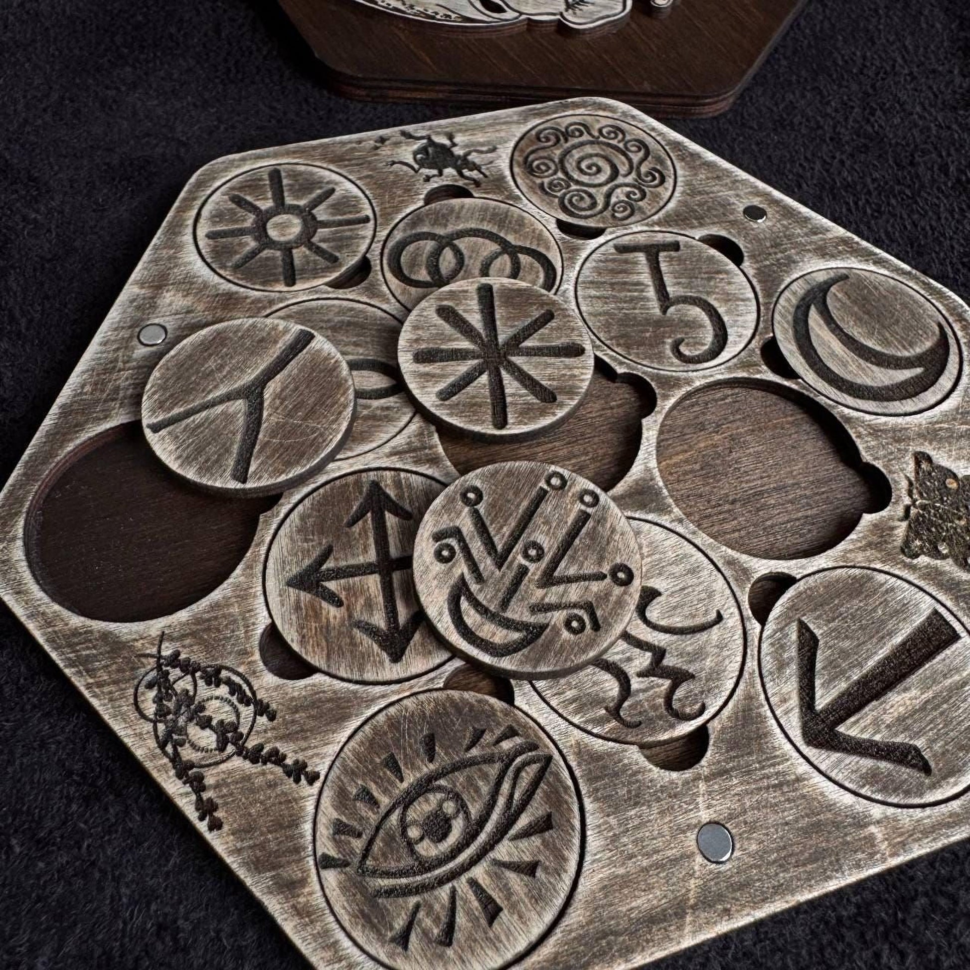 a collection of various symbols and designs carved into a wooden surface, including circular shapes and geometric patterns.