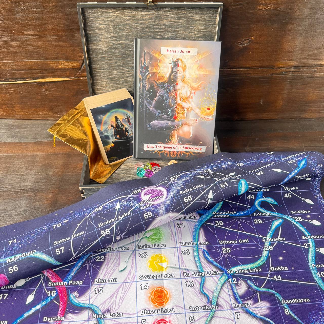 a book titled "Lila: The game of self-discovery" by Harish Johari, along with a tarot card and a map of the universe.