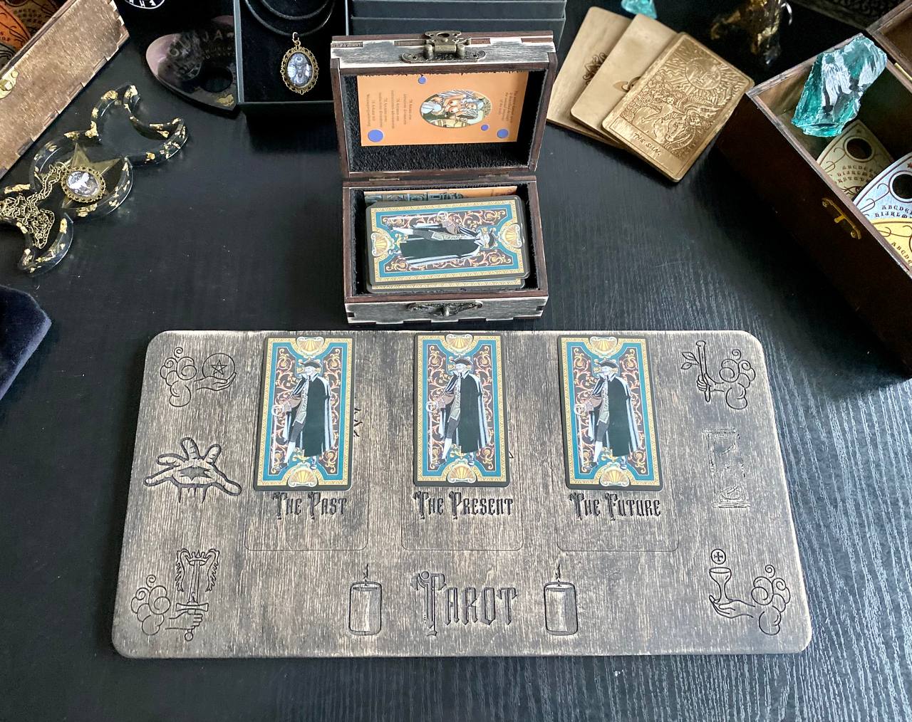 a tarot card reader's table with various items, including a wooden box, a deck of cards, and other decorative objects.