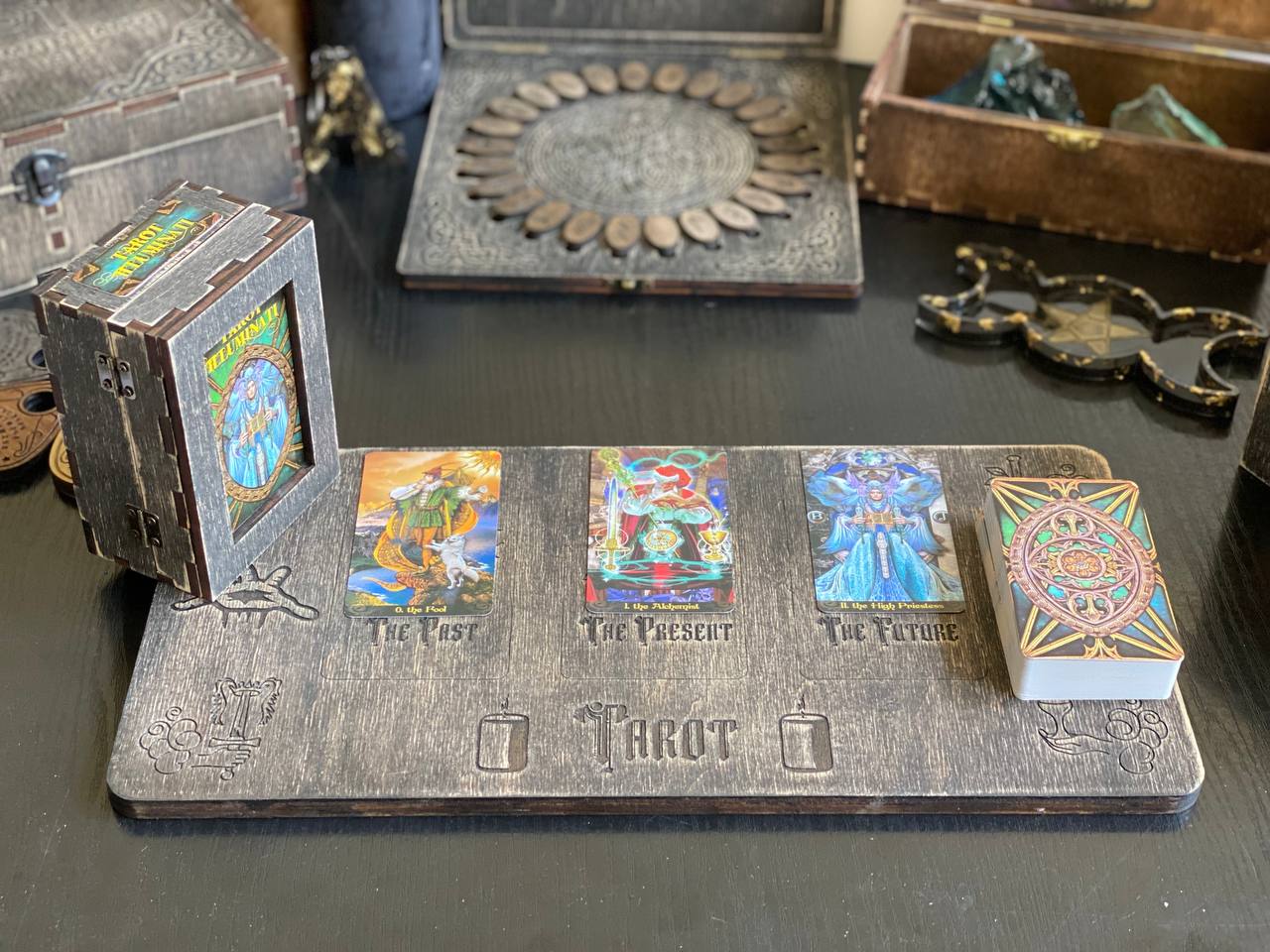 a collection of tarot cards and other objects arranged on a wooden board, possibly used for fortune-telling or divination purposes.