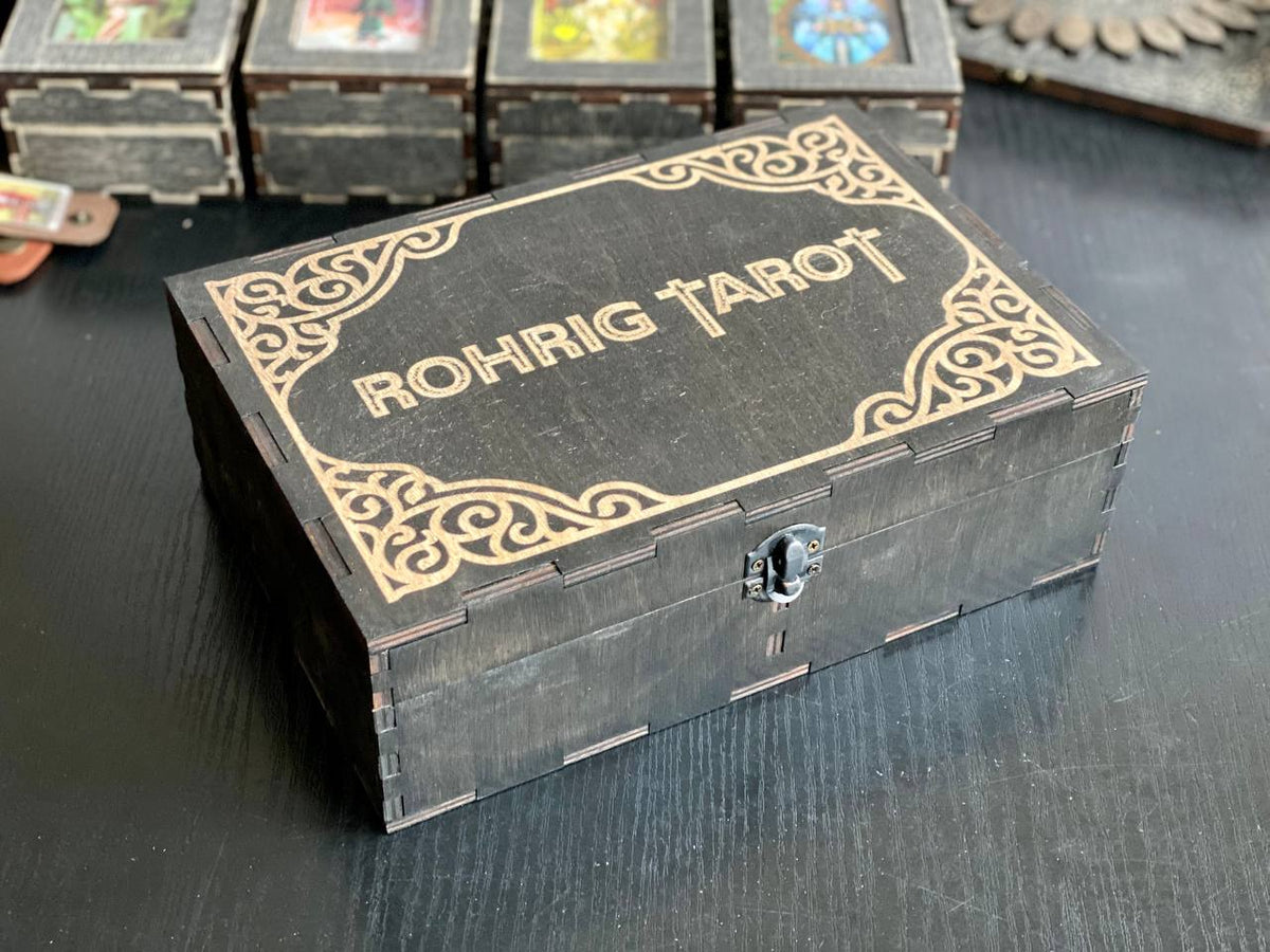 A wooden box with the name "Rohrig Tarot" printed on it, sitting on a dark surface.