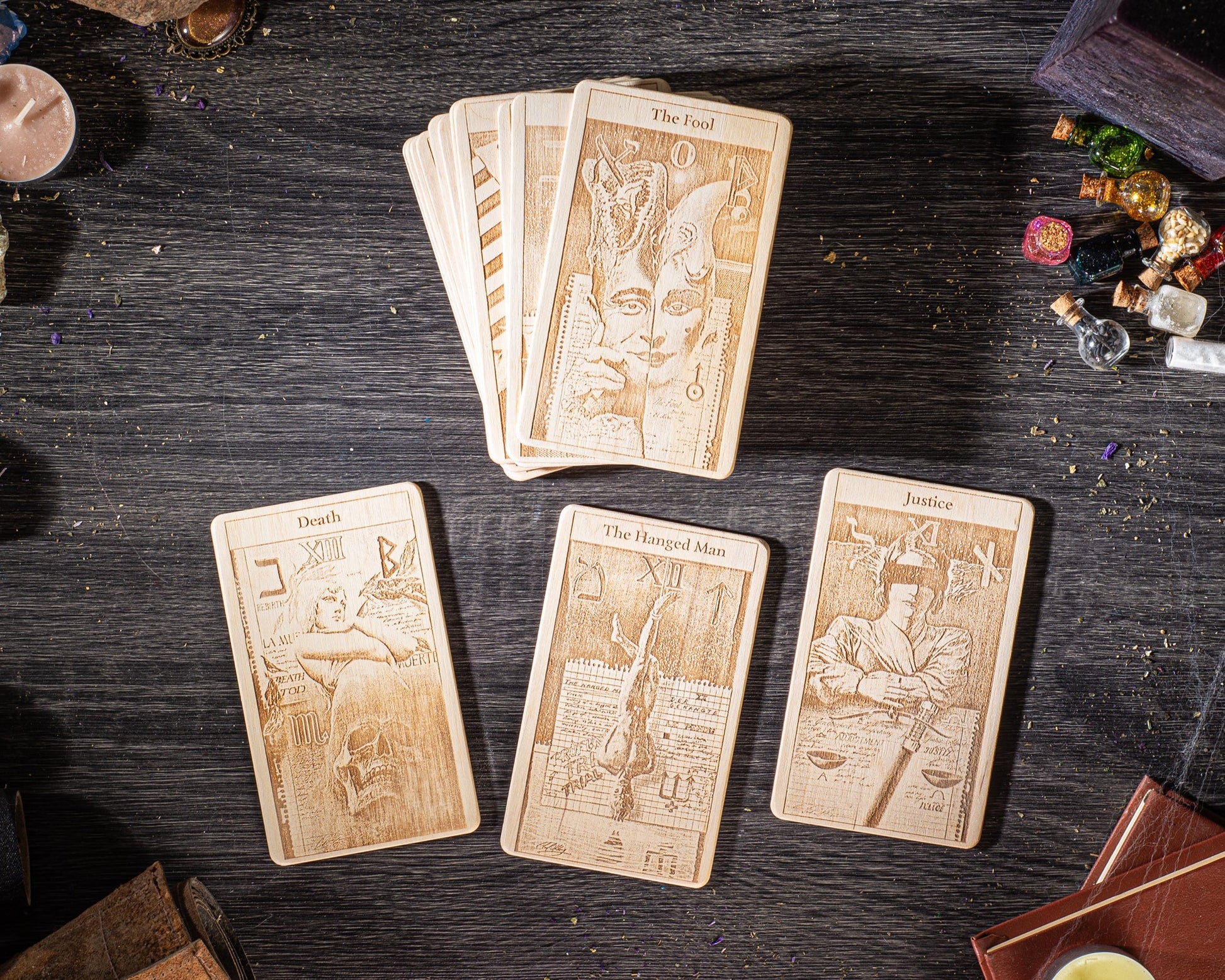 a collection of wooden tarot cards arranged on a dark wooden surface, along with various objects such as candles, incense, and other items.