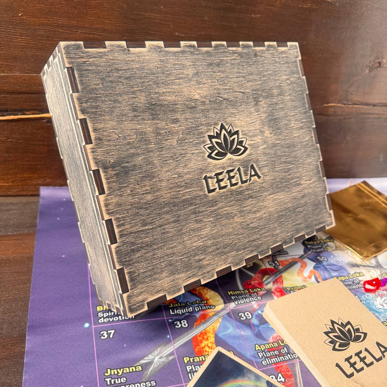 a wooden box with the word "LEEALA" printed on it, placed on a purple surface.