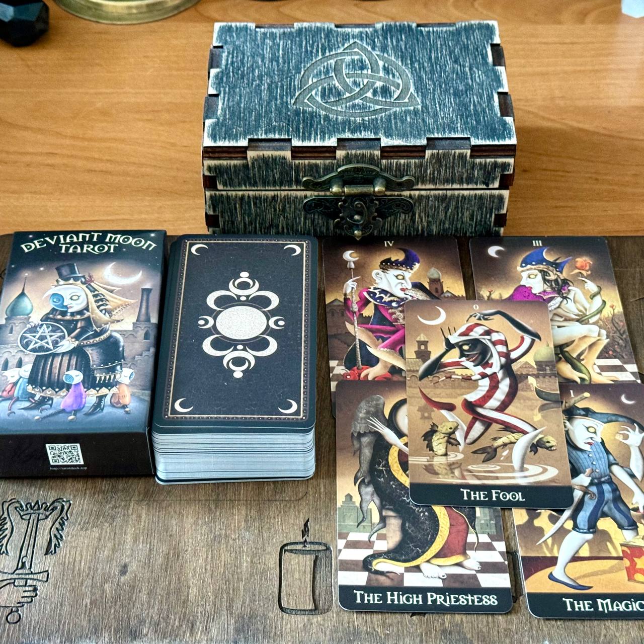 a collection of tarot cards and a wooden box, likely used for fortune-telling or divination purposes.