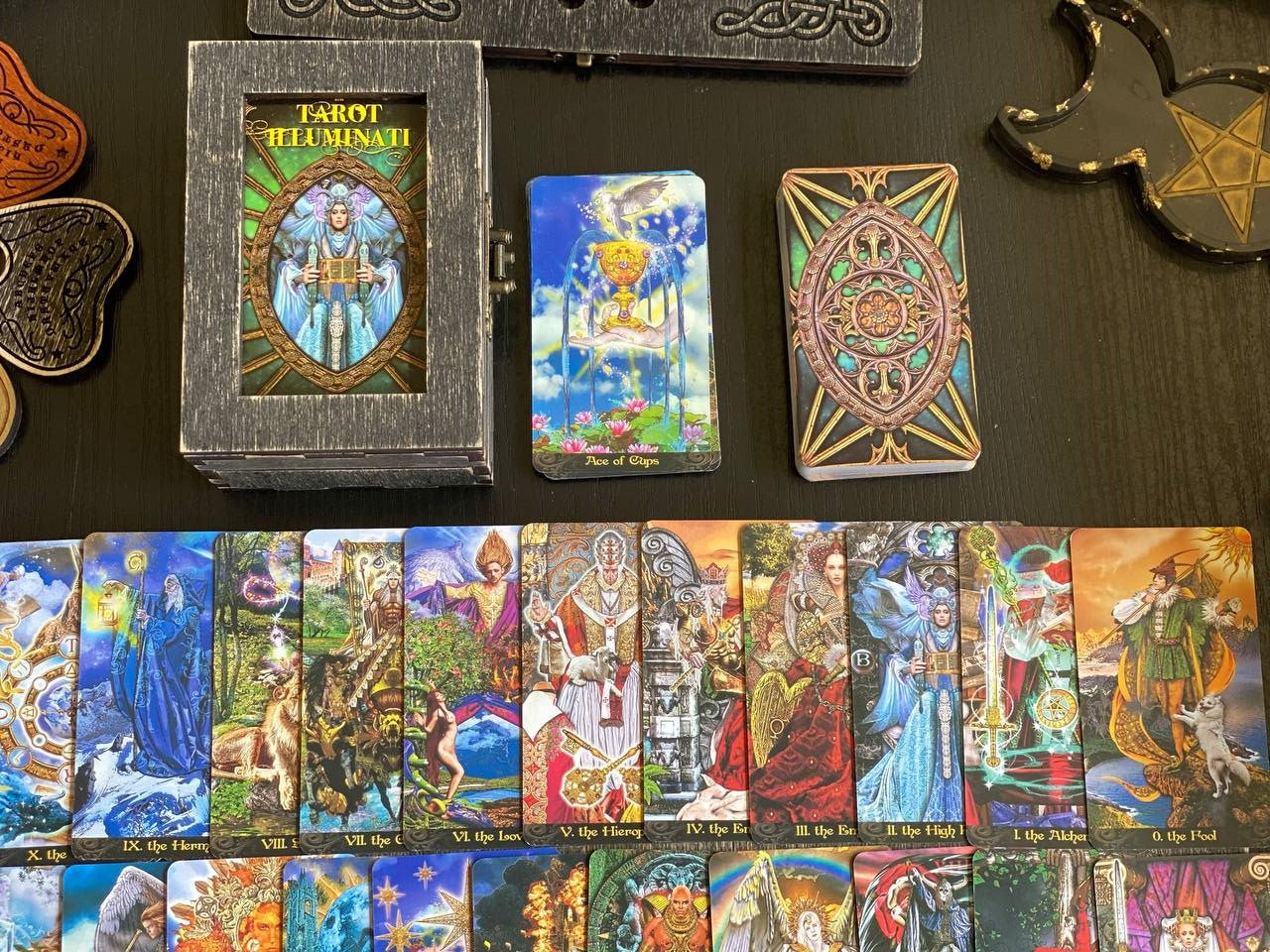 a collection of tarot cards and a fortune teller's deck, arranged on a dark surface.