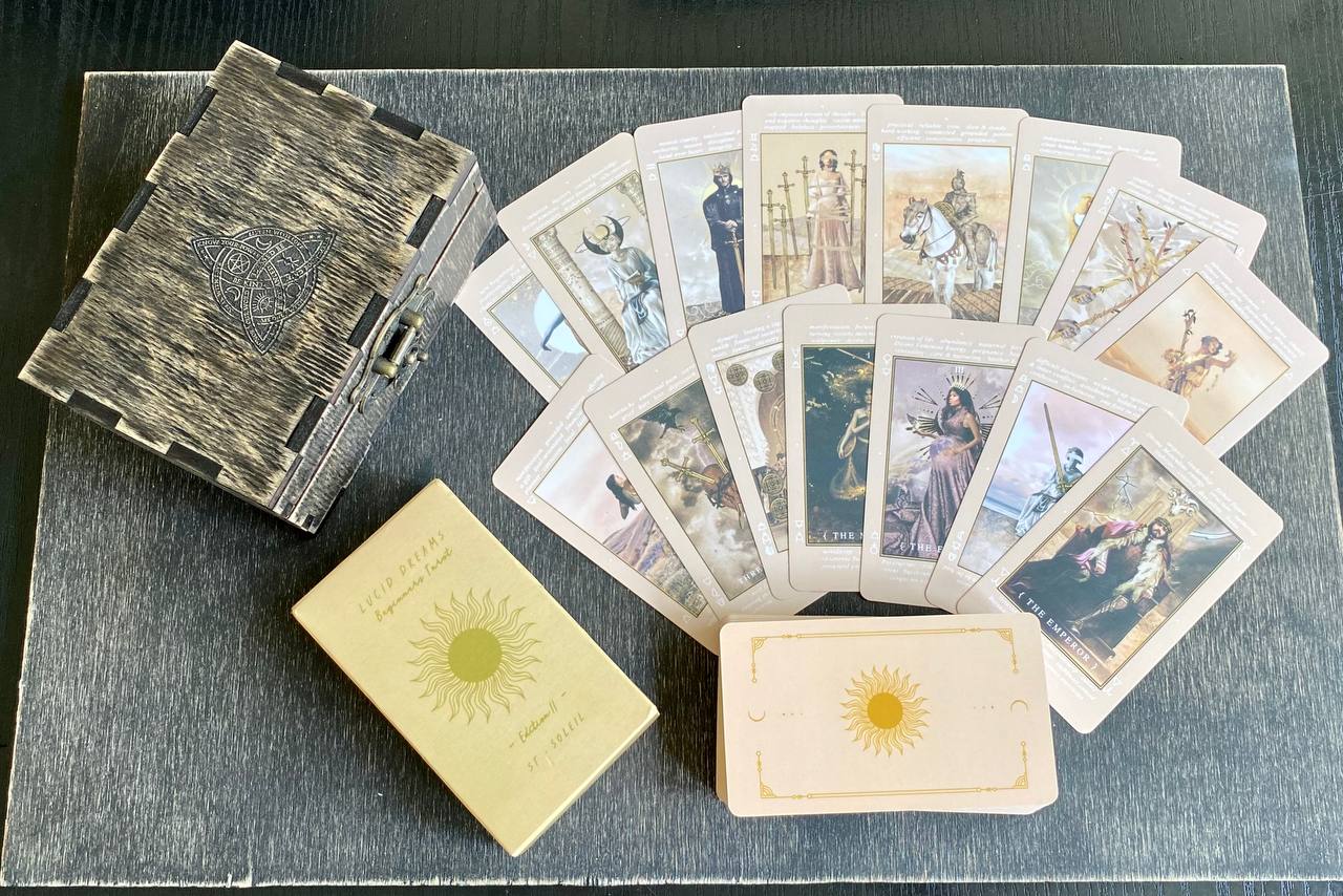 a collection of tarot cards and a wooden box, arranged on a wooden surface.