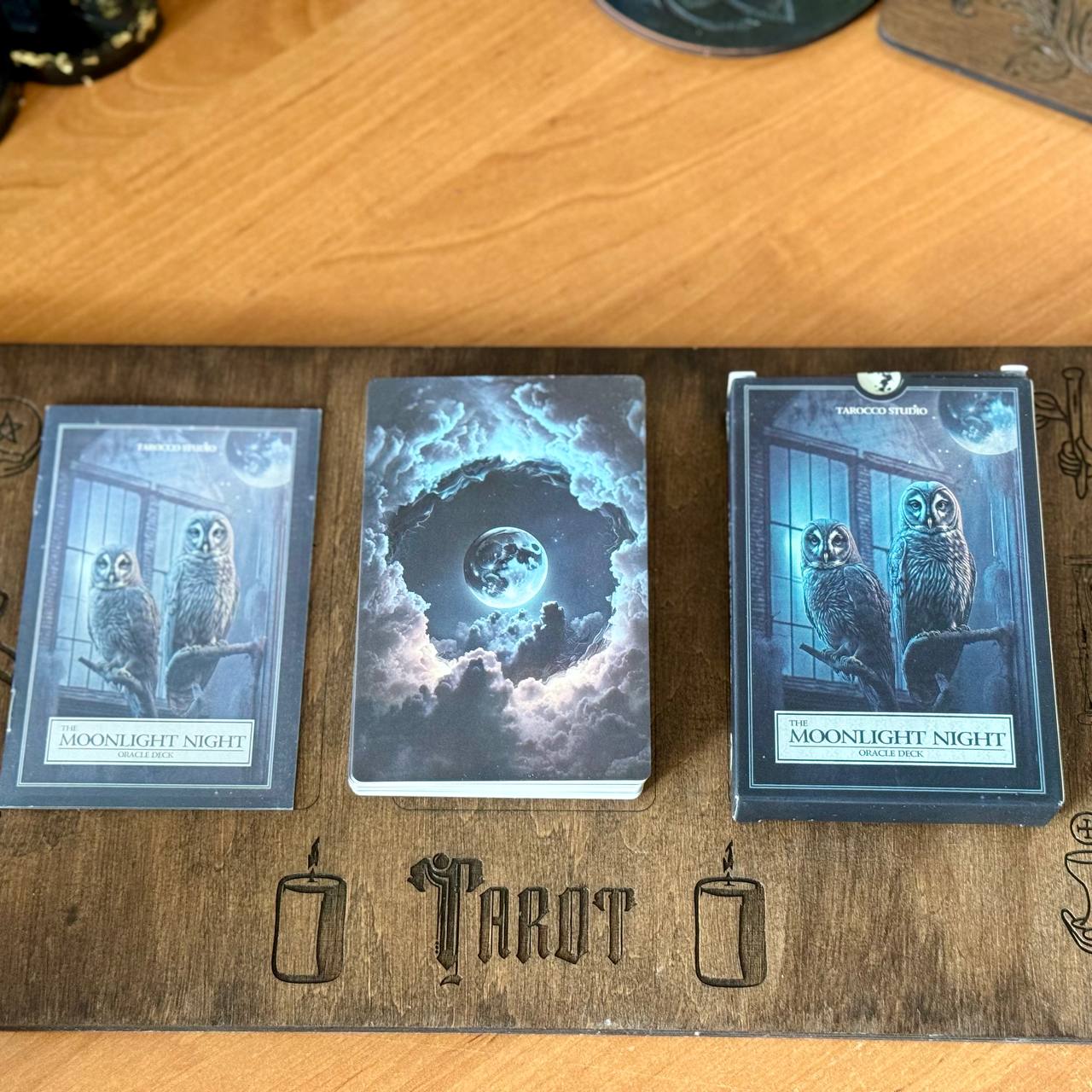 a tarot deck with three cards, each featuring an owl illustration and the title "Moonlight Night" written on them. The cards are arranged on a wooden board with the word "Tarot" written on it.