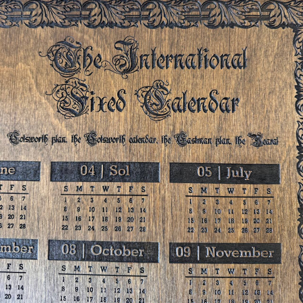 Wooden calendar with decorative text and black text on a wooden background