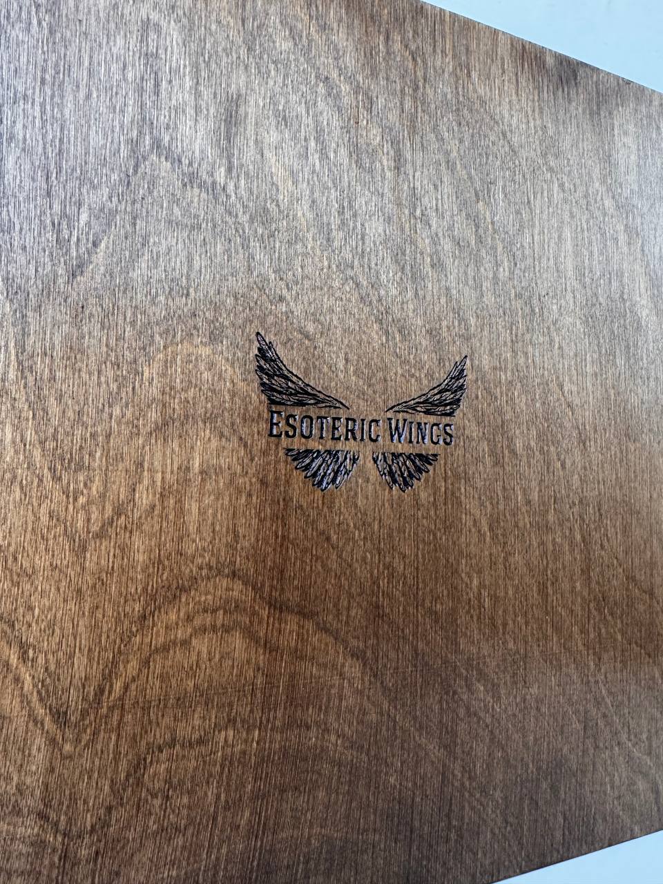 Wooden calendar with 'Esoteric Wings' branding engraved on it