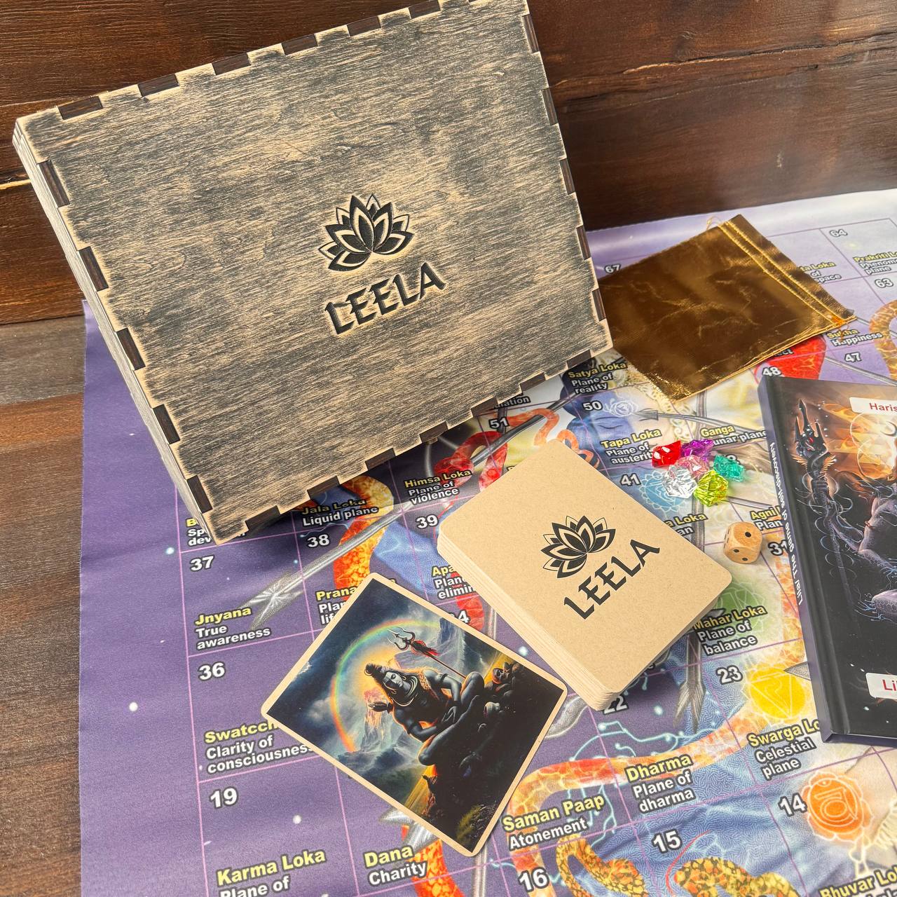 a wooden box with the word "LEEALA" printed on it, along with some game cards and a map.