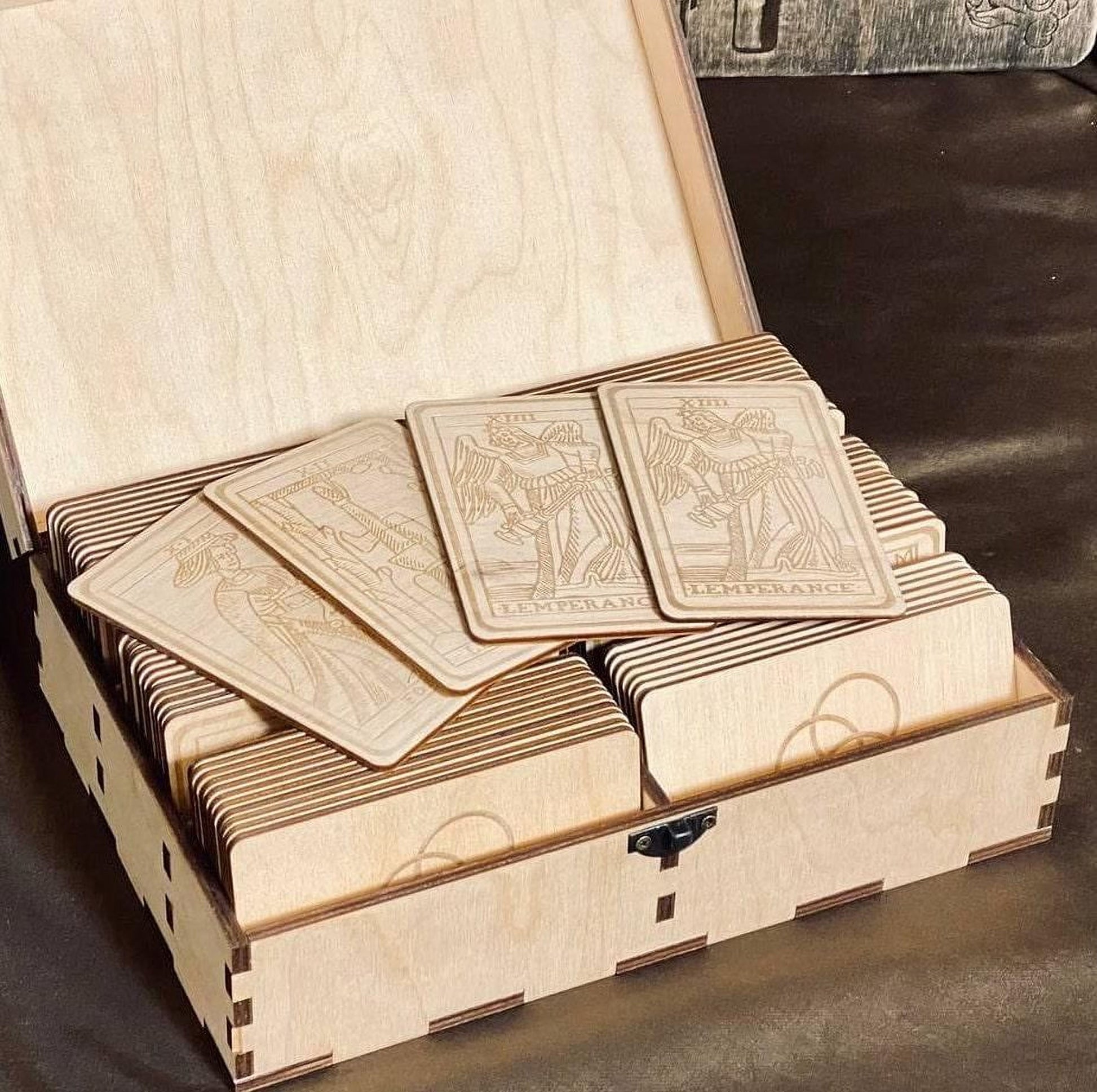 A wooden box containing several wooden tarot cards, with the cards arranged in rows inside the box.