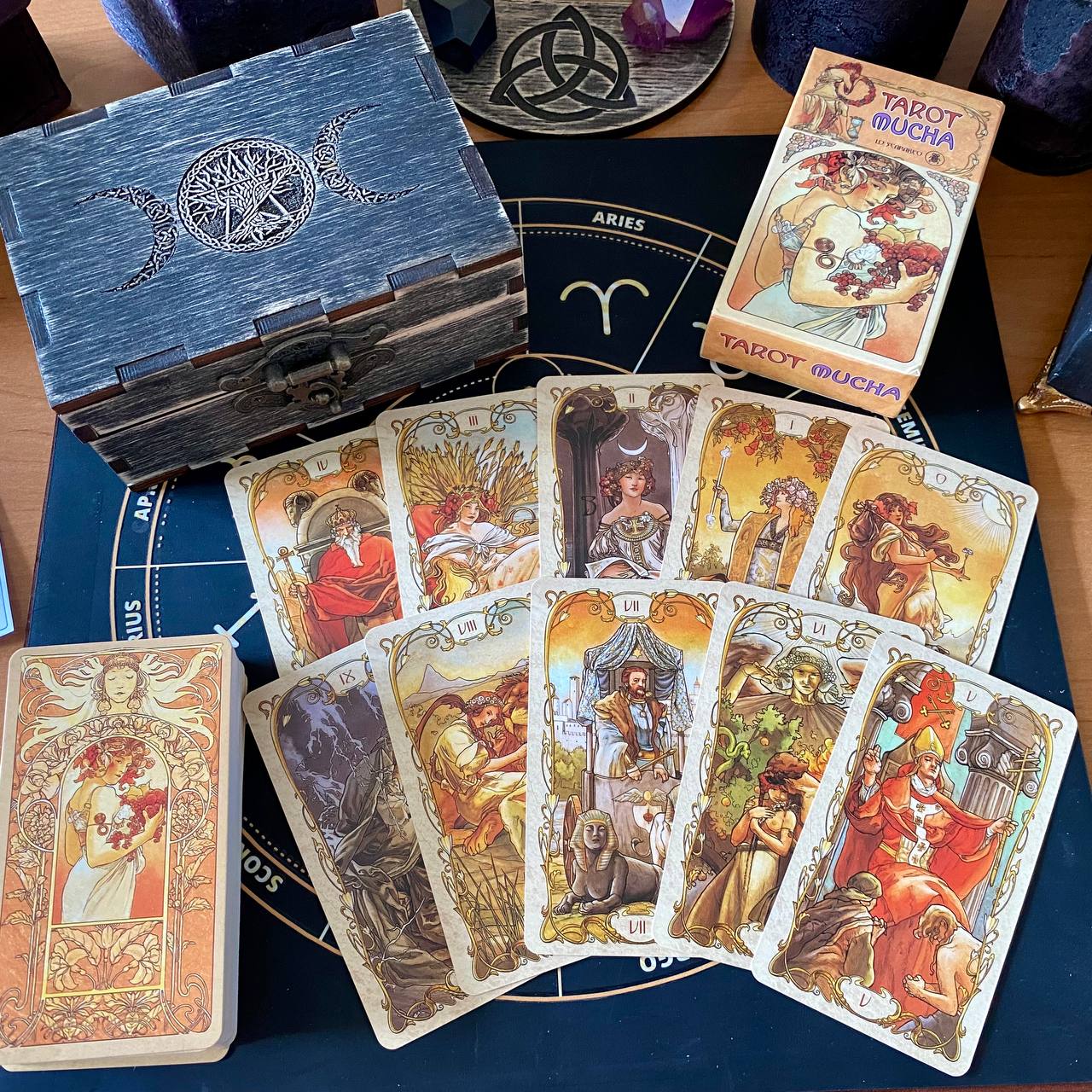 a collection of tarot cards and a wooden box, arranged on a table.