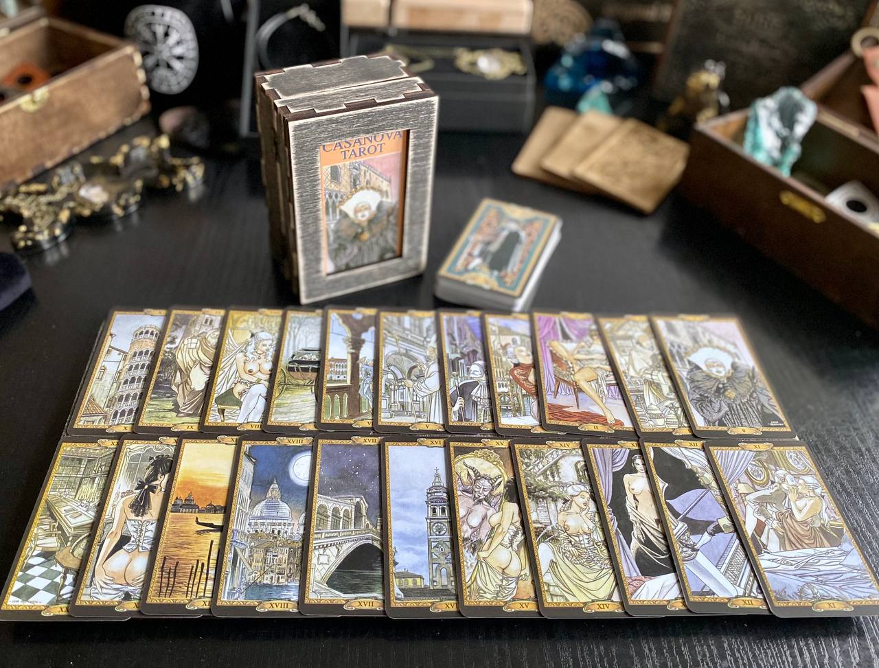 a collection of tarot cards arranged on a table, with a box of the cards in the background.