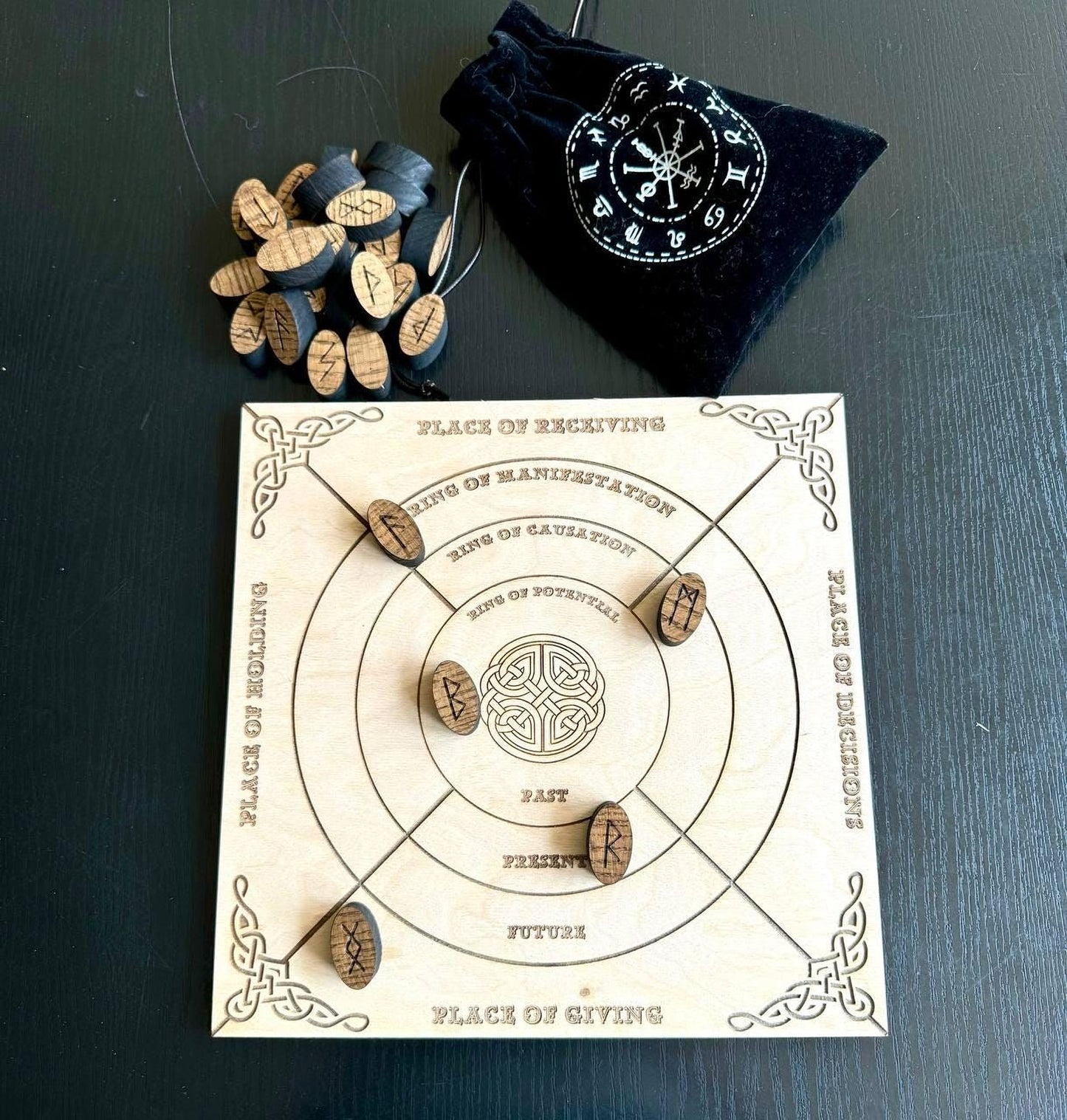a wooden board game with a black bag and wooden tokens on a dark surface.