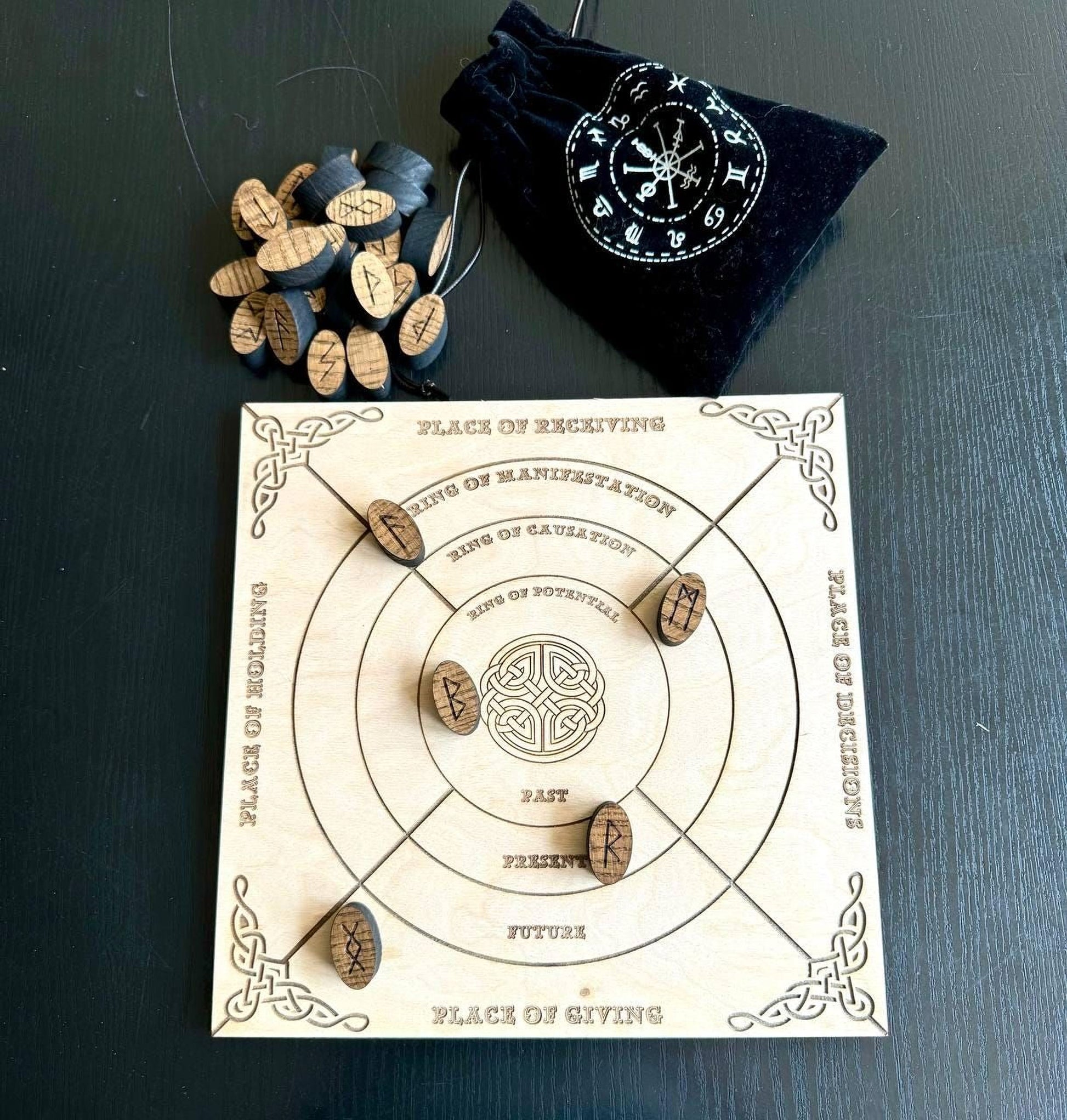 a wooden board game with a black bag and wooden tokens on a dark surface.