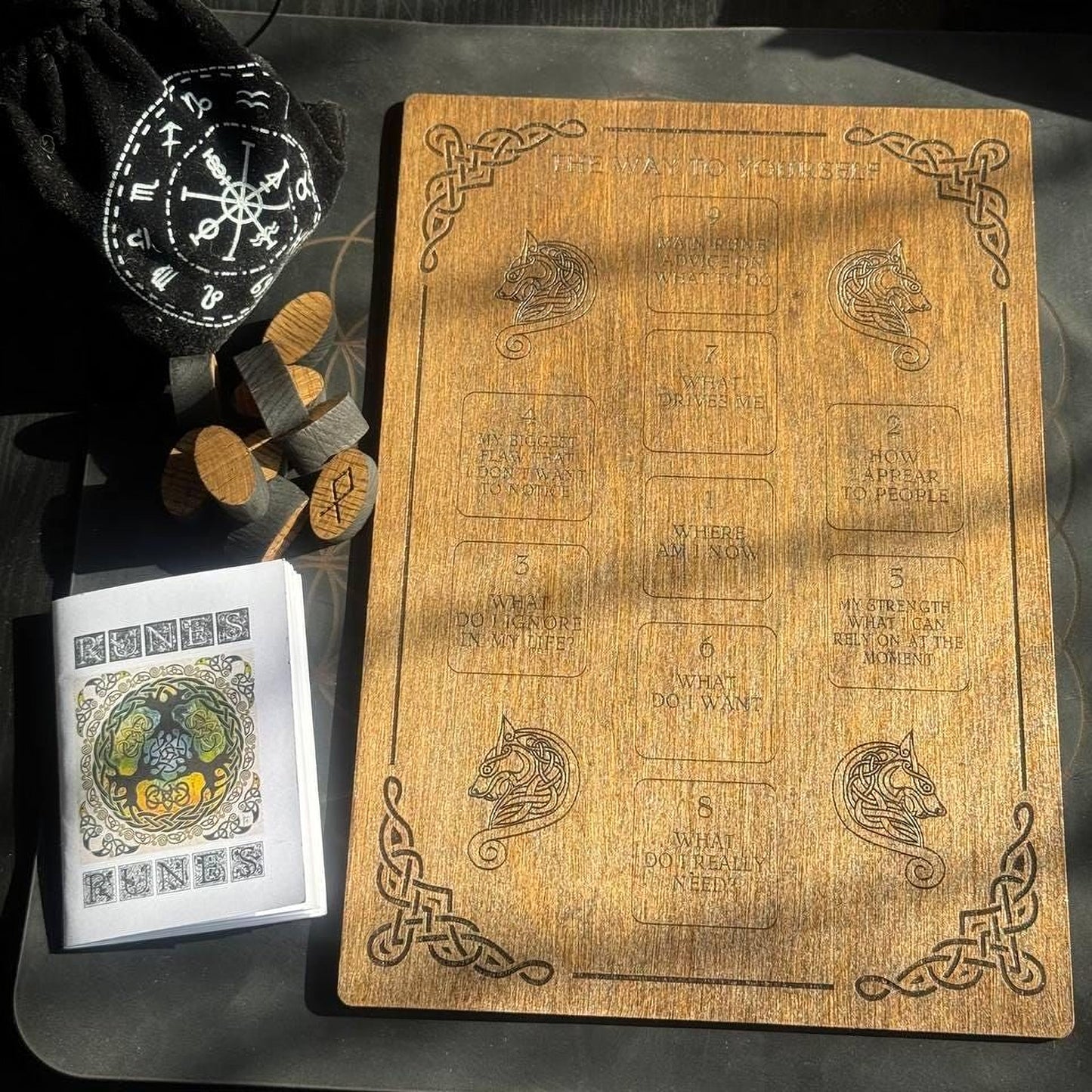 a wooden board with various texts and symbols, a small wooden puzzle, and a small wooden puzzle piece.