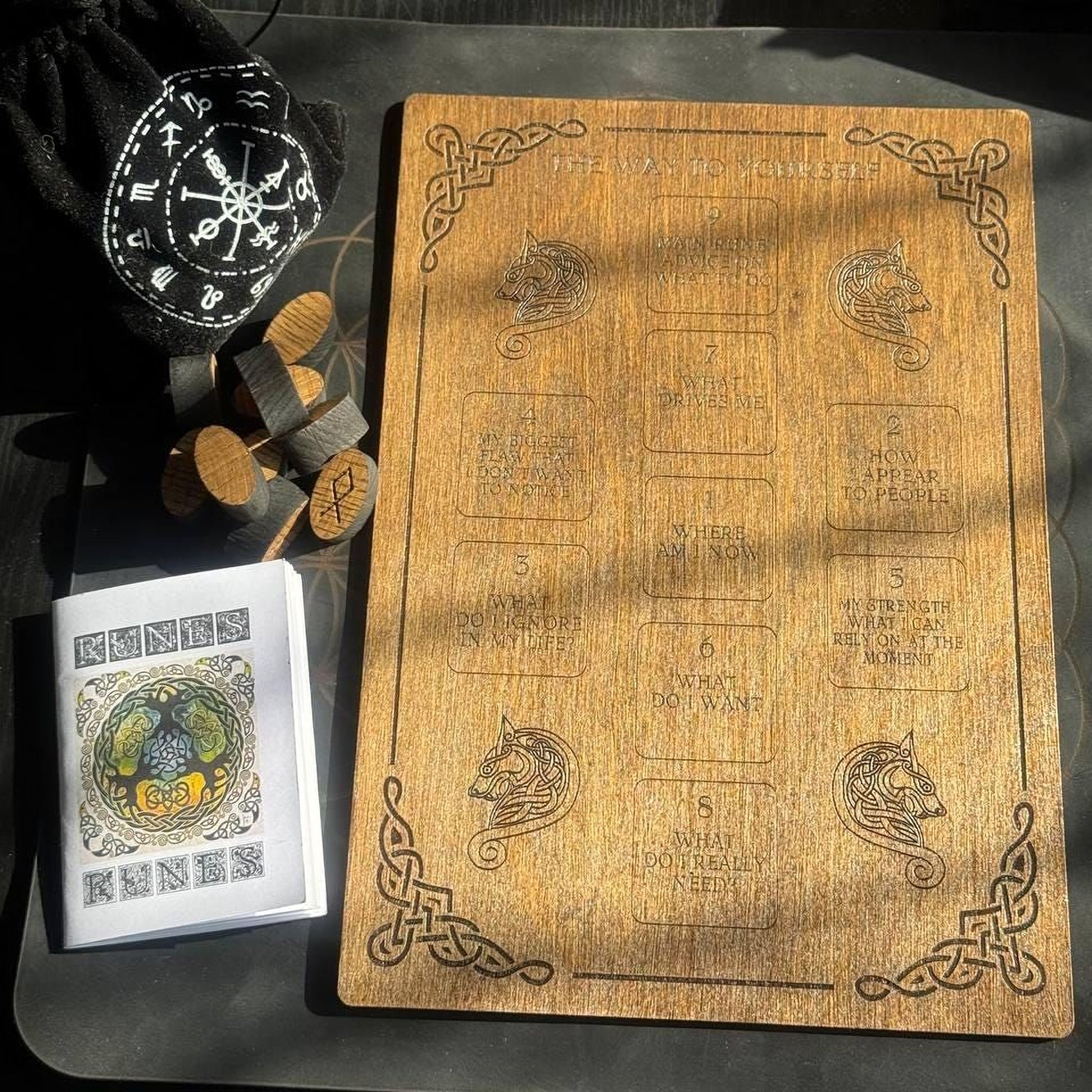 a wooden board with various texts and symbols, a small wooden puzzle, and a small wooden puzzle piece.