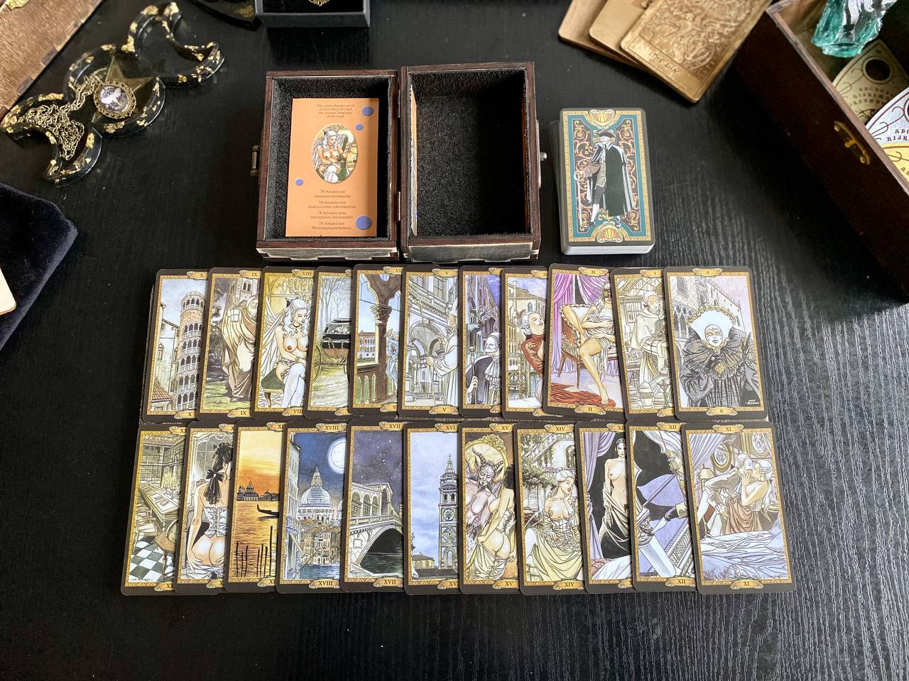 a collection of tarot cards arranged on a table, with some cards in their original boxes and others in their open compartments.