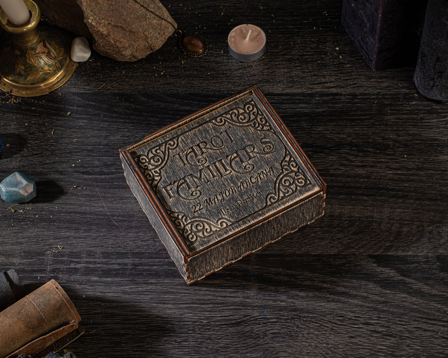 a wooden box with a decorative design, placed on a dark wooden surface.