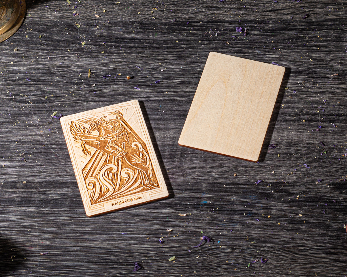 a wooden coaster with an intricate design, placed on a wooden surface with scattered purple leaves.