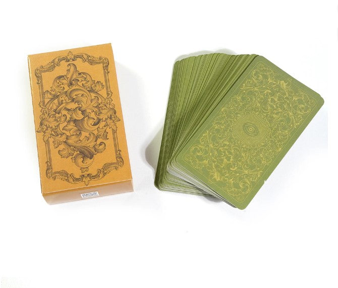 a set of ornate playing cards, including a box and a stack of green cards, all placed on a white background.