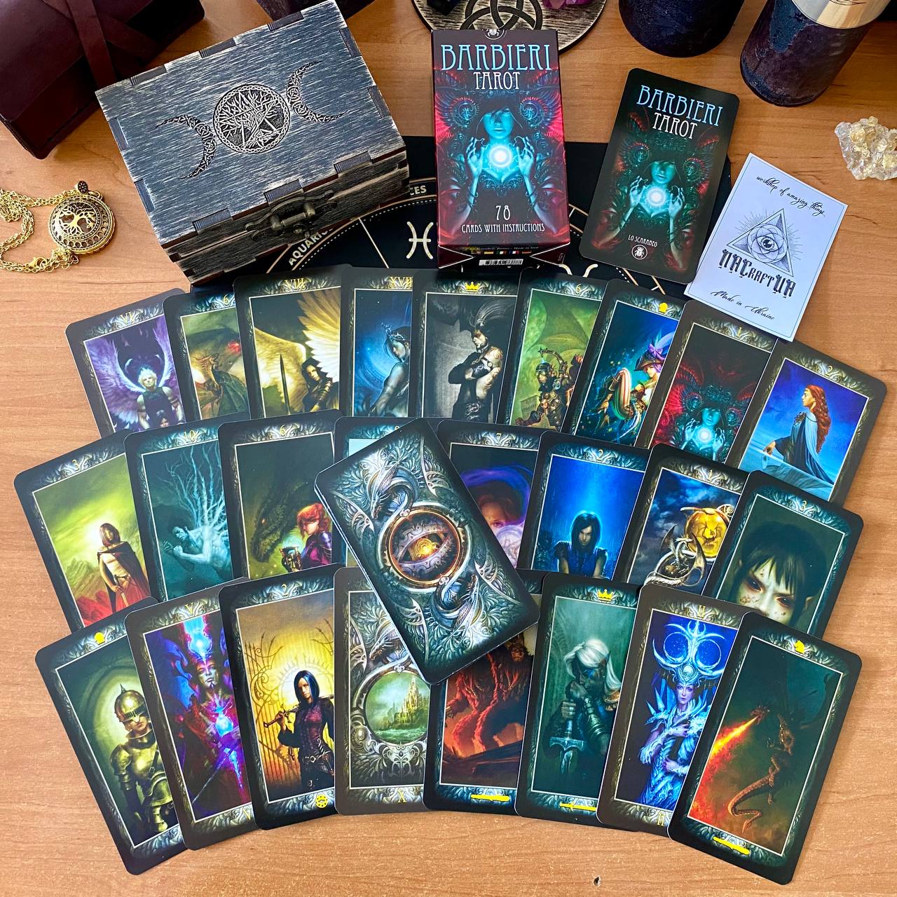 a collection of tarot cards and a wooden box, possibly containing additional items related to tarot or fantasy-themed objects.