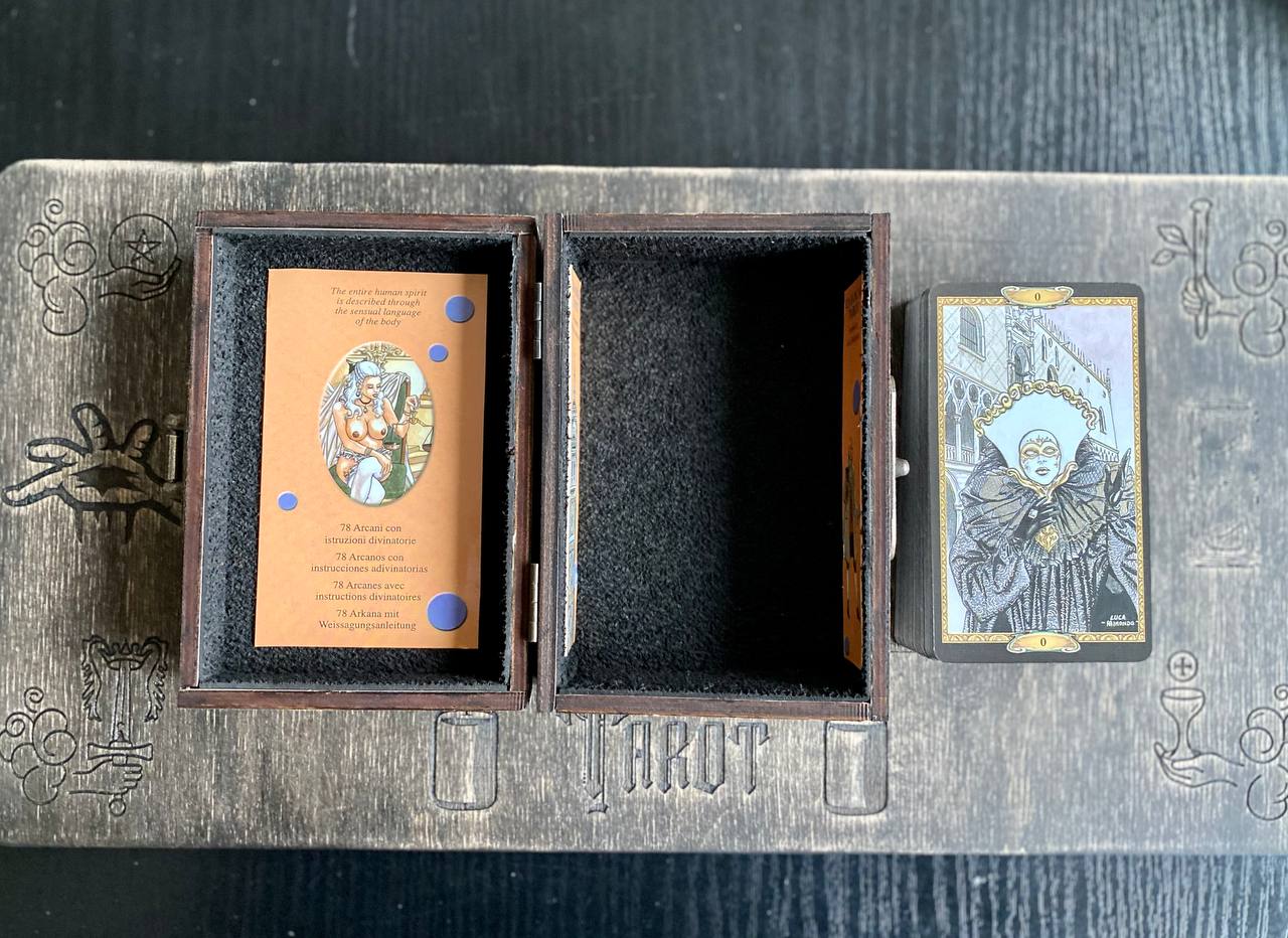 a tarot card box with a tarot card inside, placed on a wooden surface.
