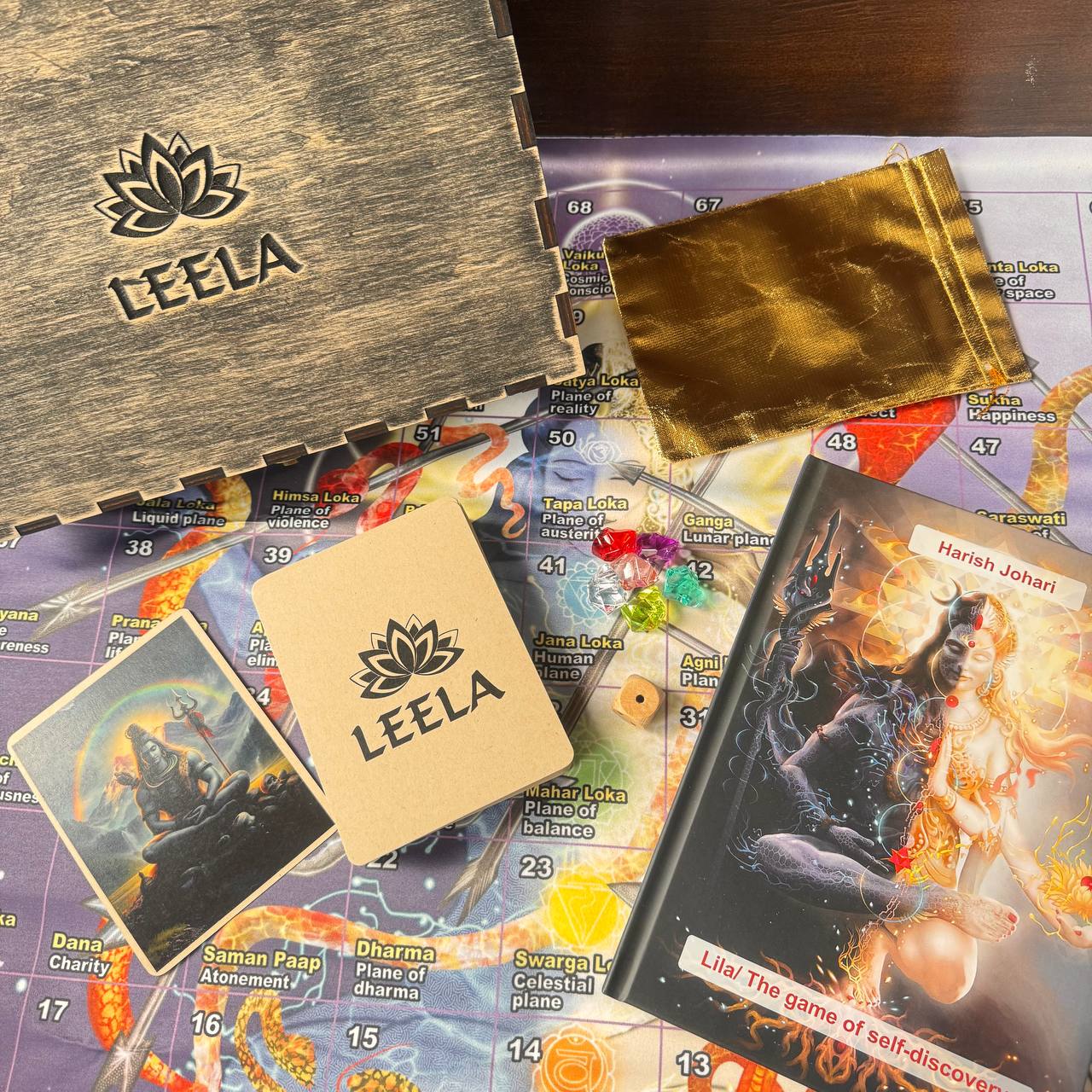 various items related to a board game, including a wooden box, a map, a book, and some accessories.
