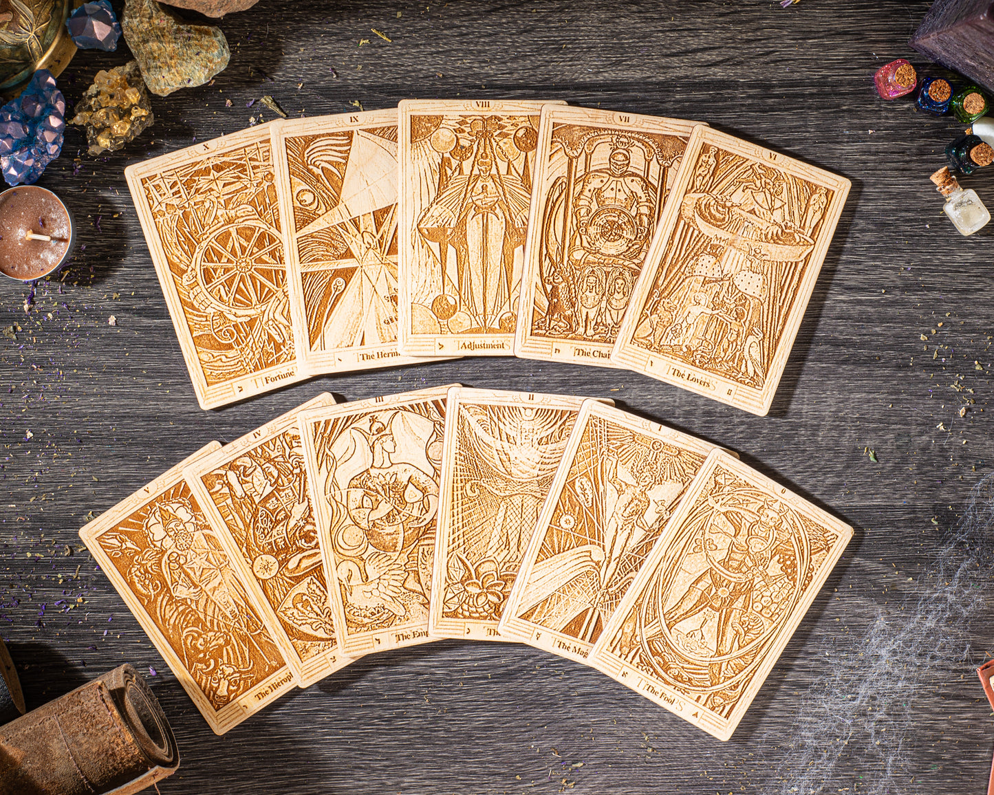 A collection of wooden tarot cards arranged on a wooden surface, with various intricate designs and illustrations.