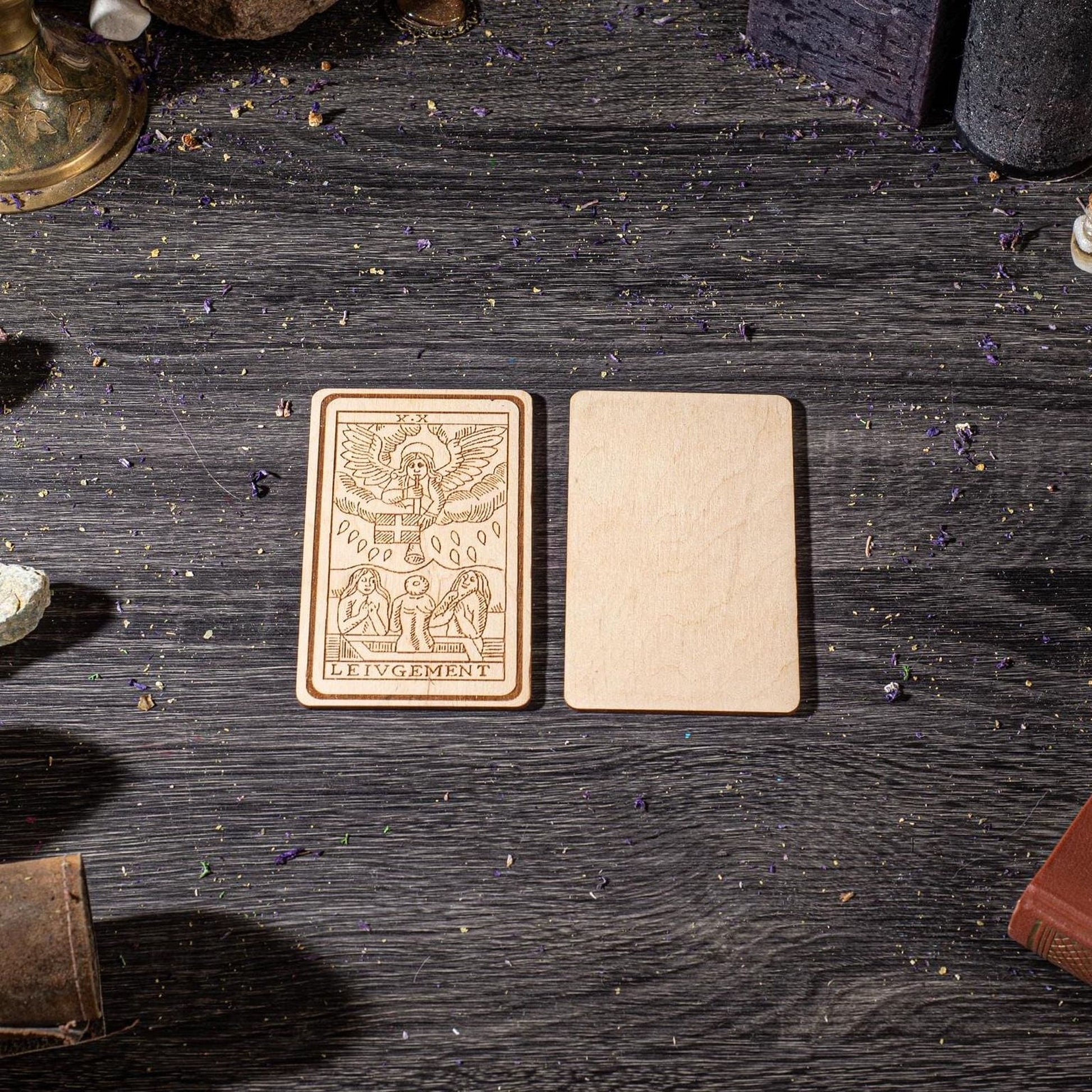two wooden cards placed on a wooden surface, surrounded by various objects such as books and a lamp.