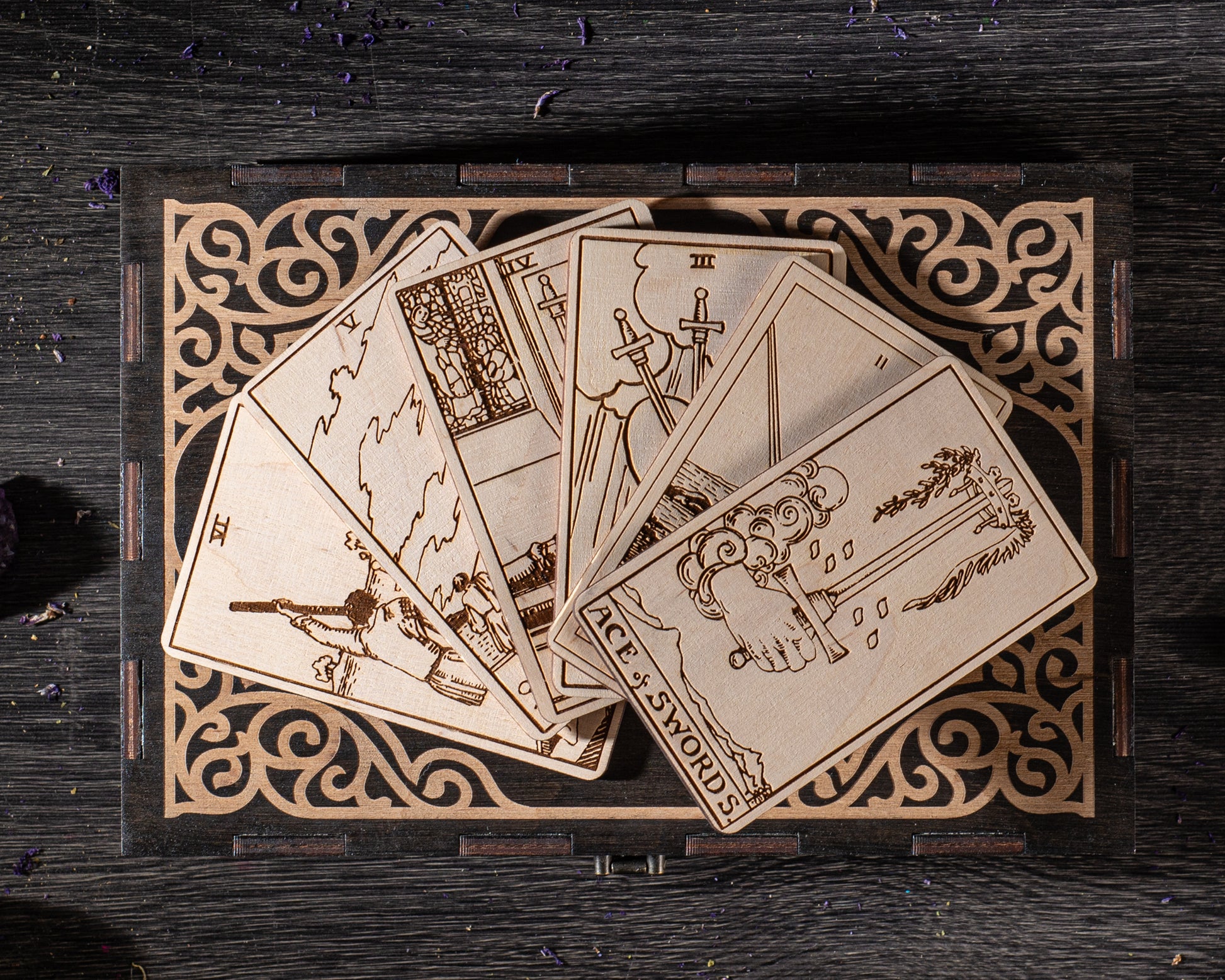 A wooden deck of playing cards with intricate designs and illustrations, including tarot cards, is displayed on a wooden stand with a decorative border.