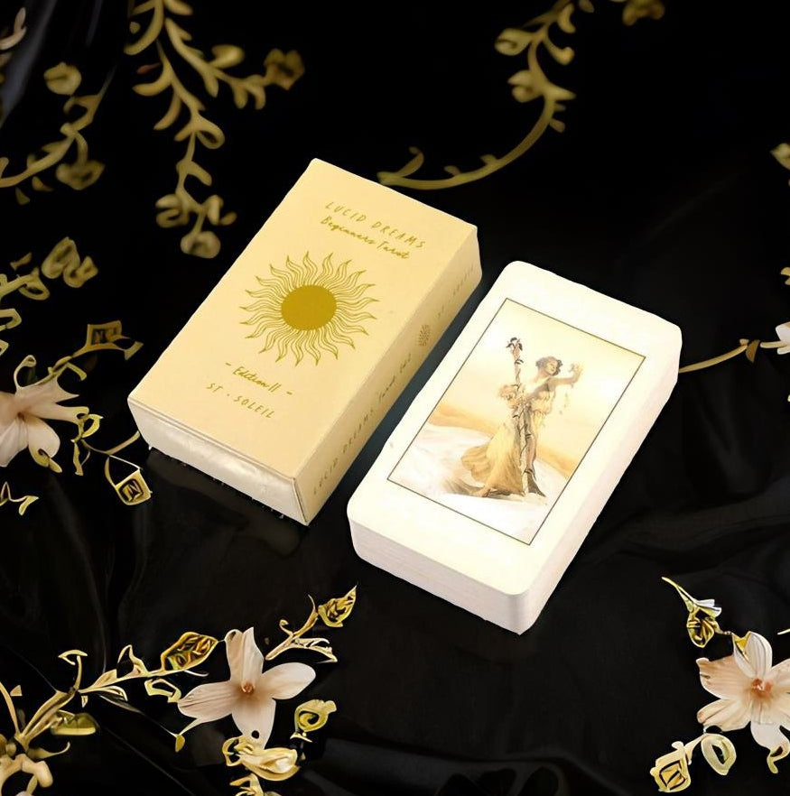 a deck of playing cards with a gold-colored box and a white-colored card placed on a black background with gold floral designs.
