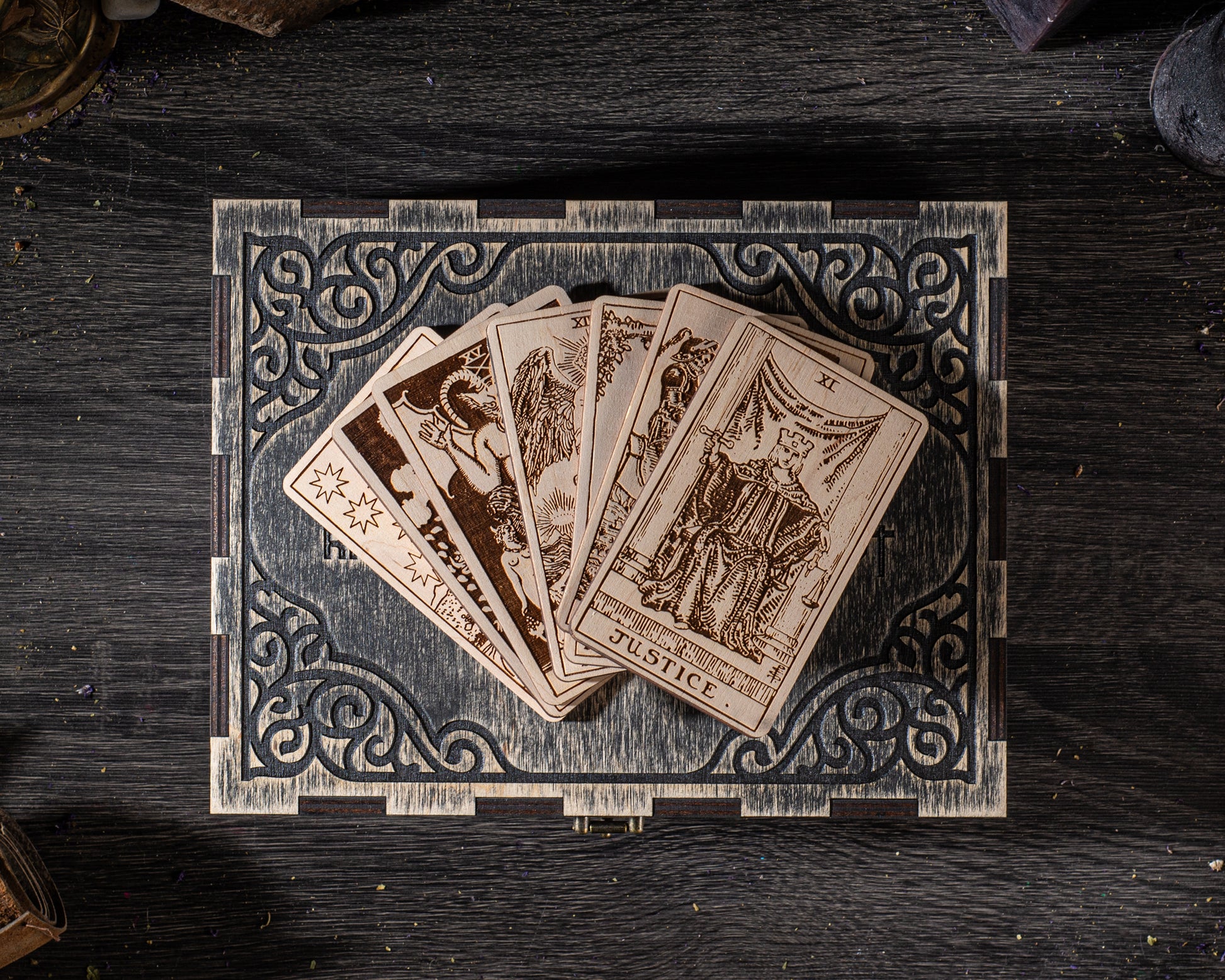 A deck of playing cards is displayed on a wooden box with an ornate, decorative border.