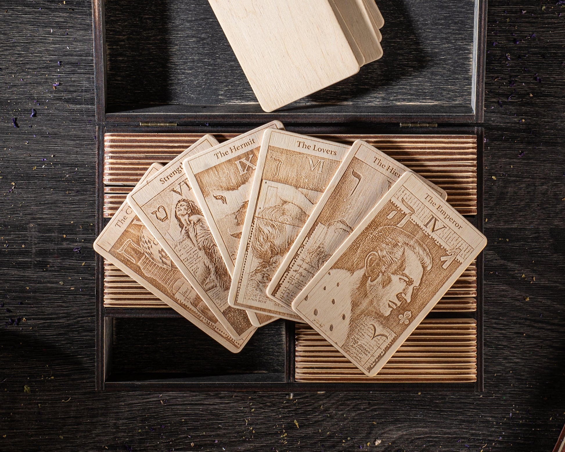 A deck of playing cards with intricate designs and text, arranged on a wooden surface.