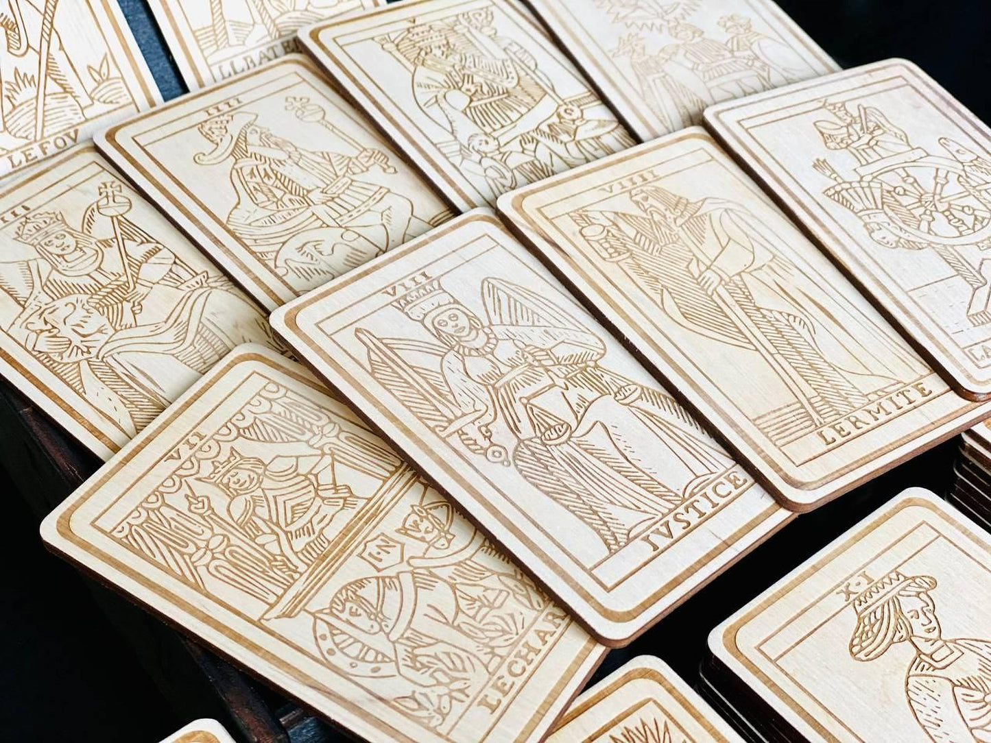 a collection of wooden tarot cards, each with intricate designs and illustrations. The cards are arranged in a way that showcases their detailed artwork, creating a visually appealing display.