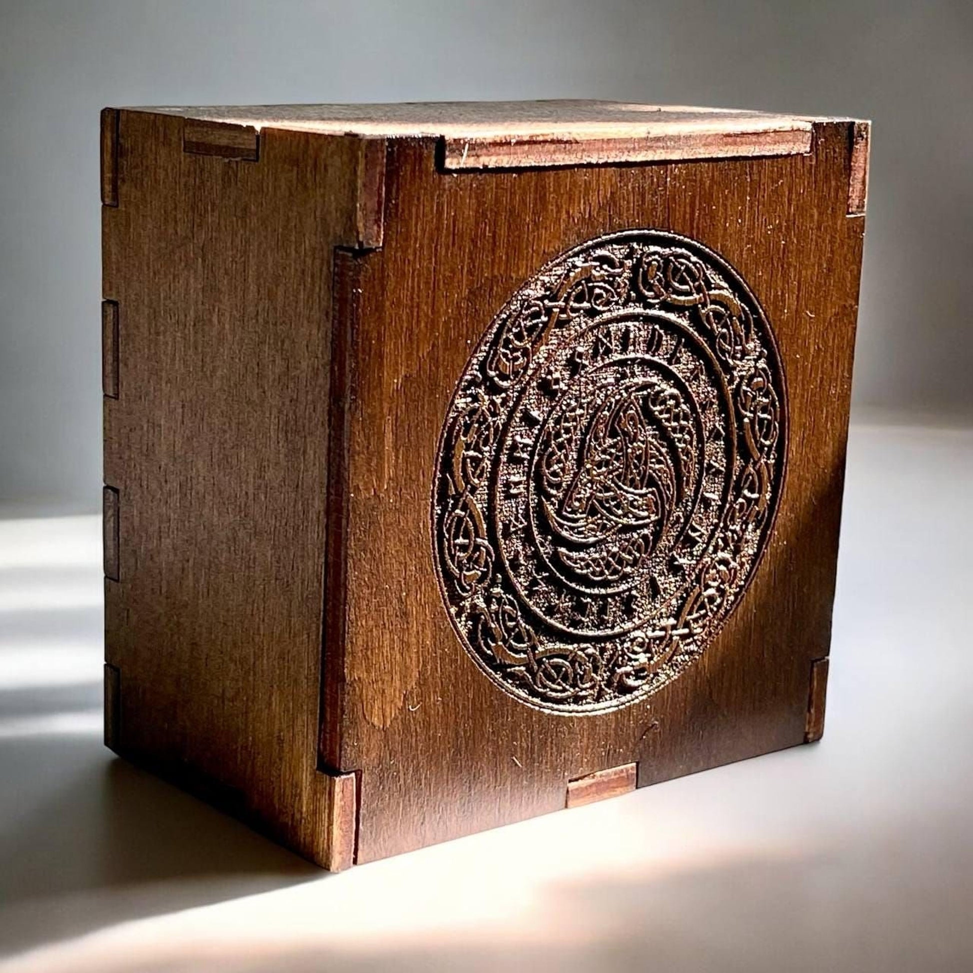 A wooden box with an intricate carved design on the front.